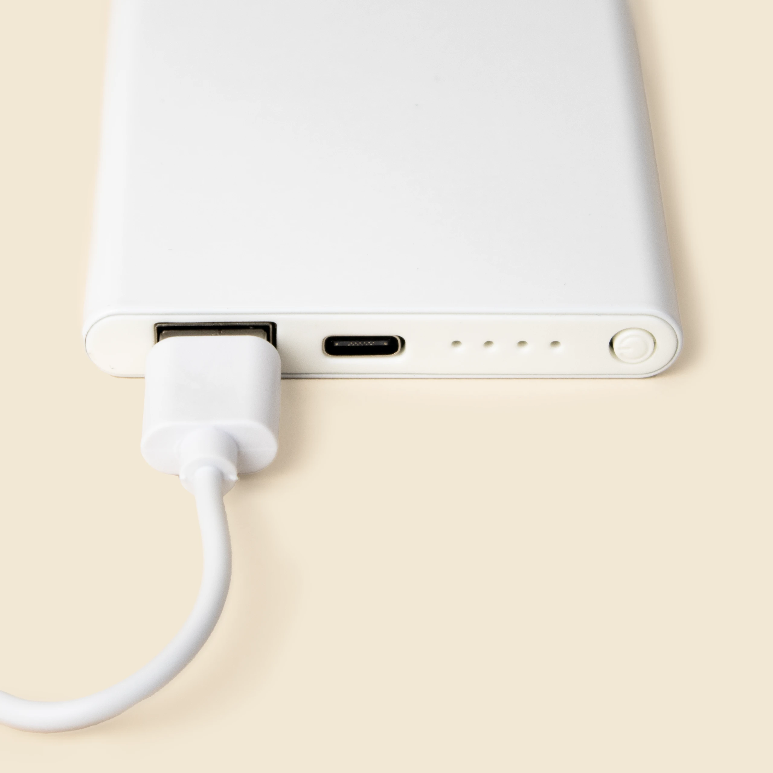 Detalle de cable enchufado a una batería portátil de color blanco