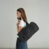 Chica llevando una bolsa de viaje negra de la marca Lefrik personalizada con el logotipo de "Sheedo"