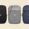 3 mochilas (negra, gris y azul marino) de la marca Lefrik personalizada con el texto "YOUR LOGO" en blanco