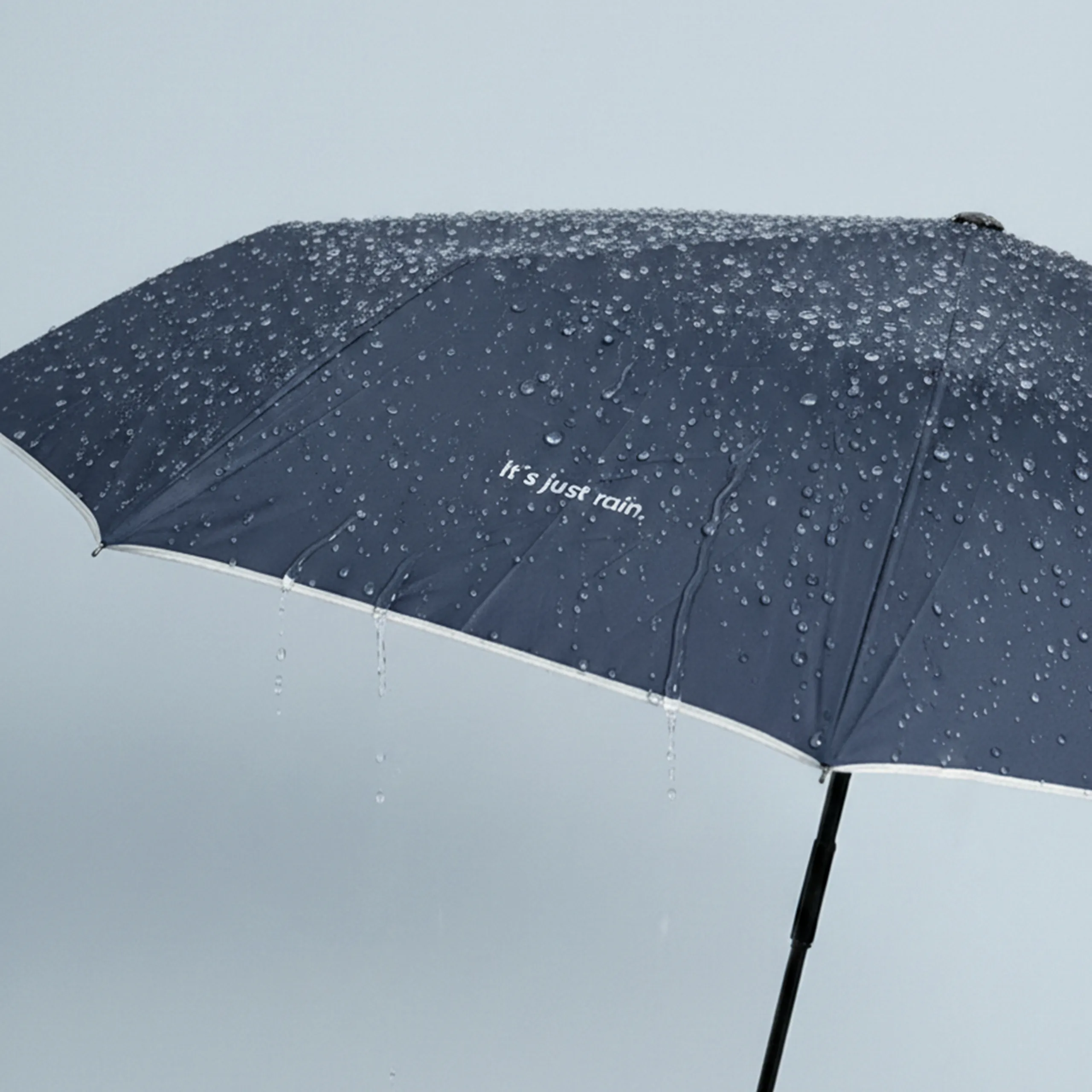 Paraguas con logo NILO Paraguas azul oscuro con logo y linea reflectante. Con apertura automática y gotas por encima.