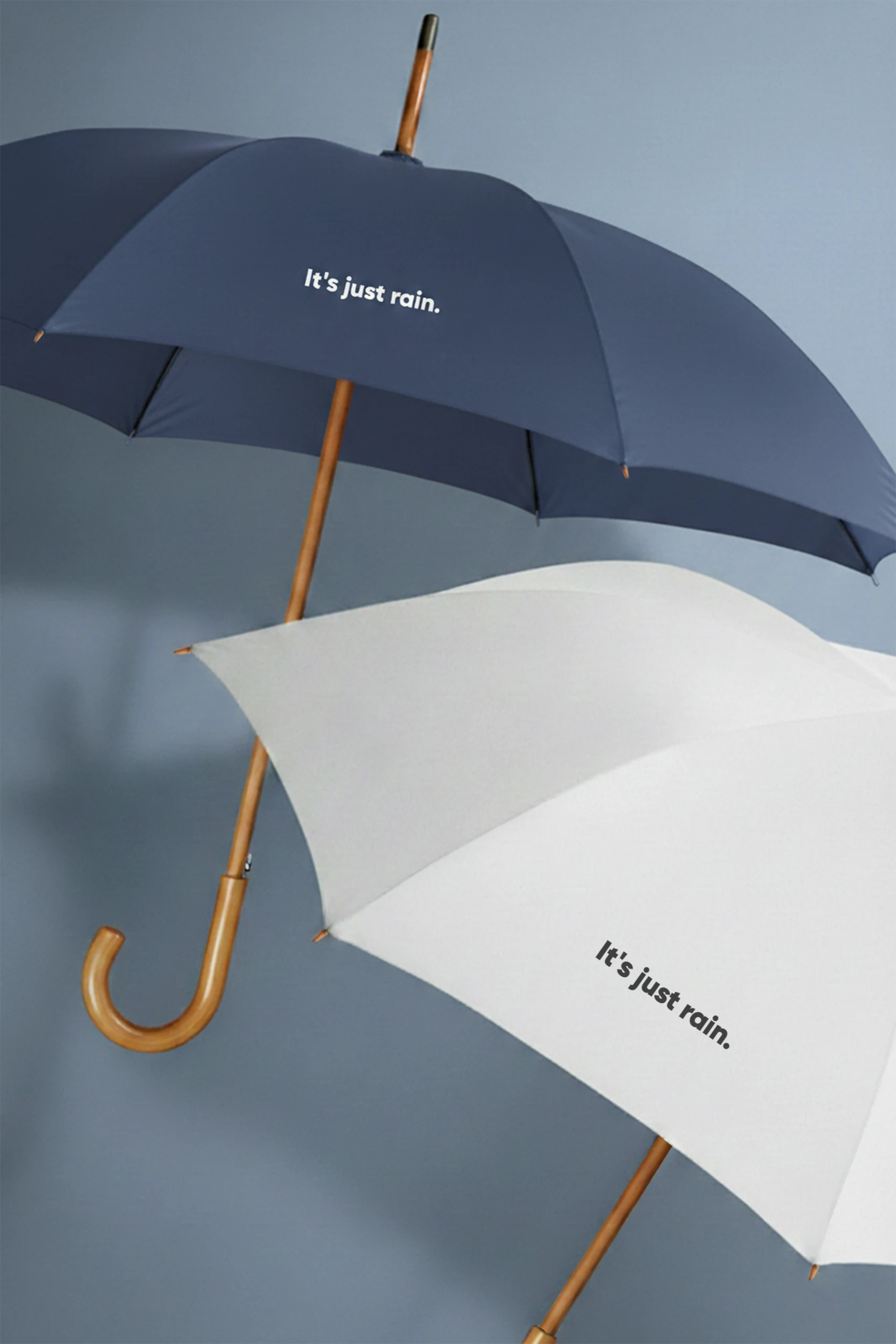 Paraguas corporativos abiertos con mango de madera automático . De color azul marino y blanco .