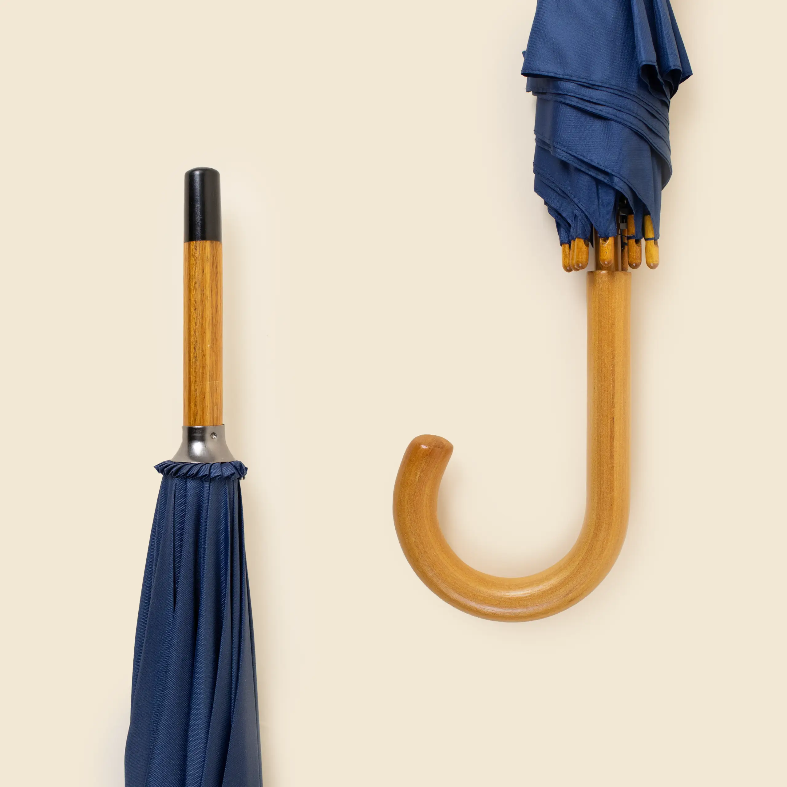 Paraguas corporativo de madera ZEUS Paraguas corporativo plegado con mango de madera automático y puntera negra. De color azul marino .