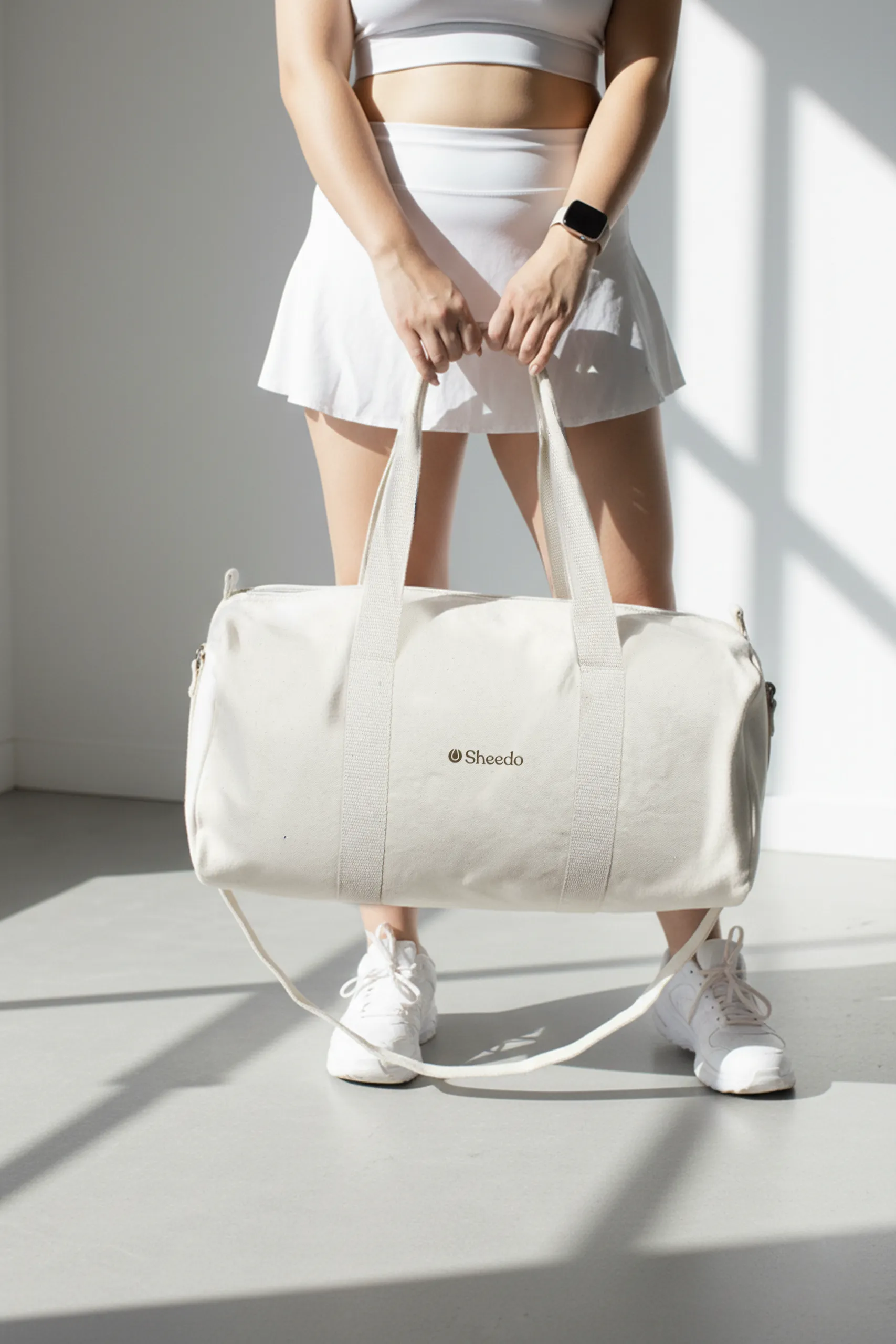 Deportista con bolsa de gimnasio personalizada. De algodón reciclado y color beige. Con personalización a todo color marrón.