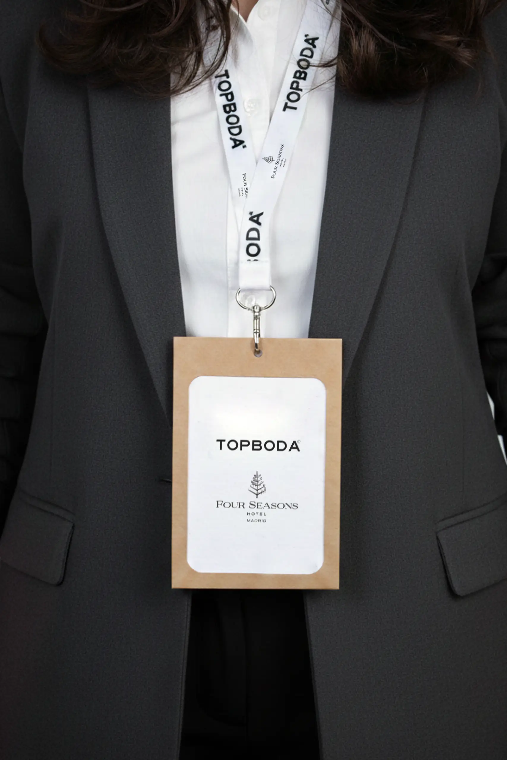 Acreditación con funda en kraft y lanyard colgados del cuello de una chica y personalizados para Topboda Four Seasons