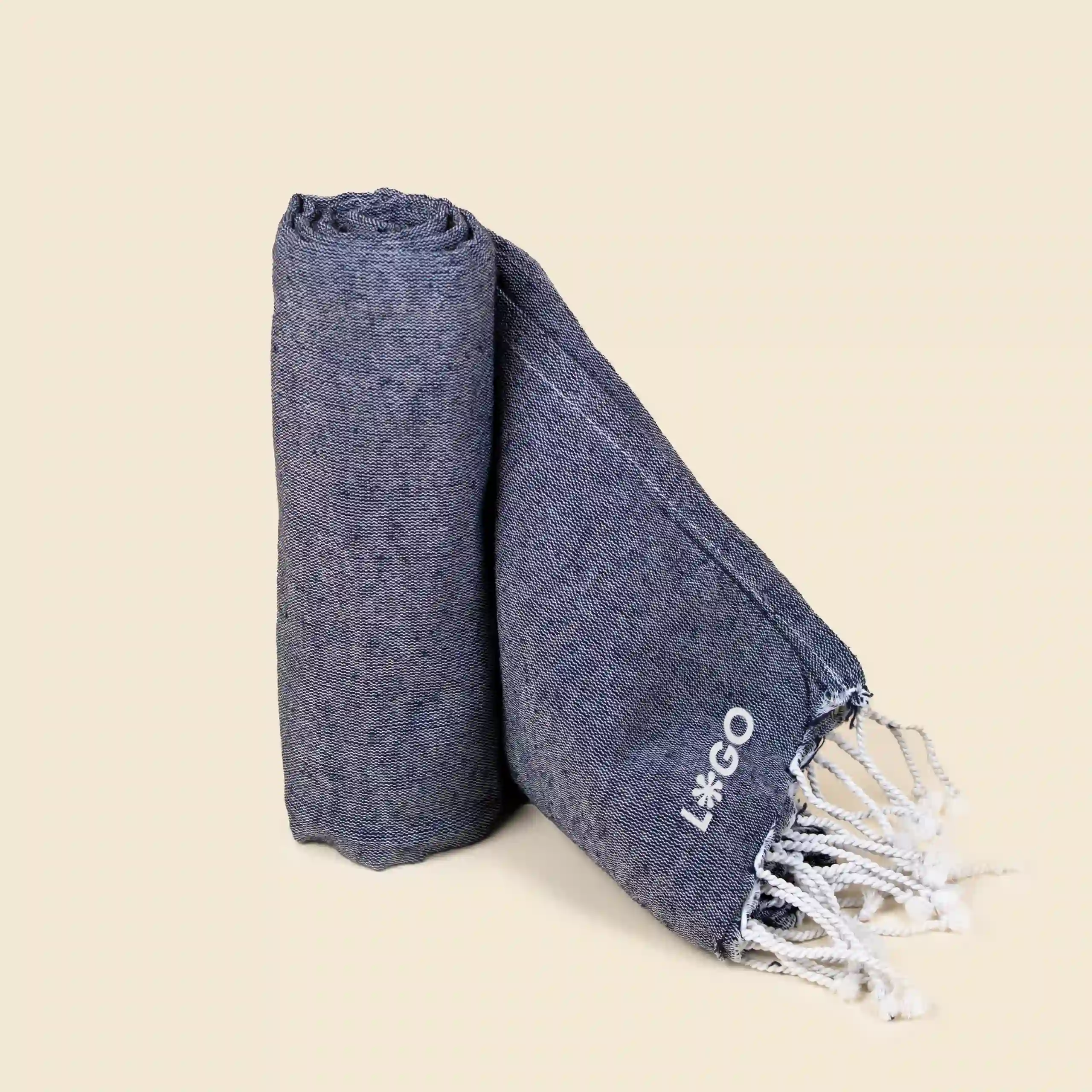 Toalla de playa personalizada_CAPRI Toalla de playa personalizada con logo blanco. Fabricado de RPET. De color azul y con flecos.