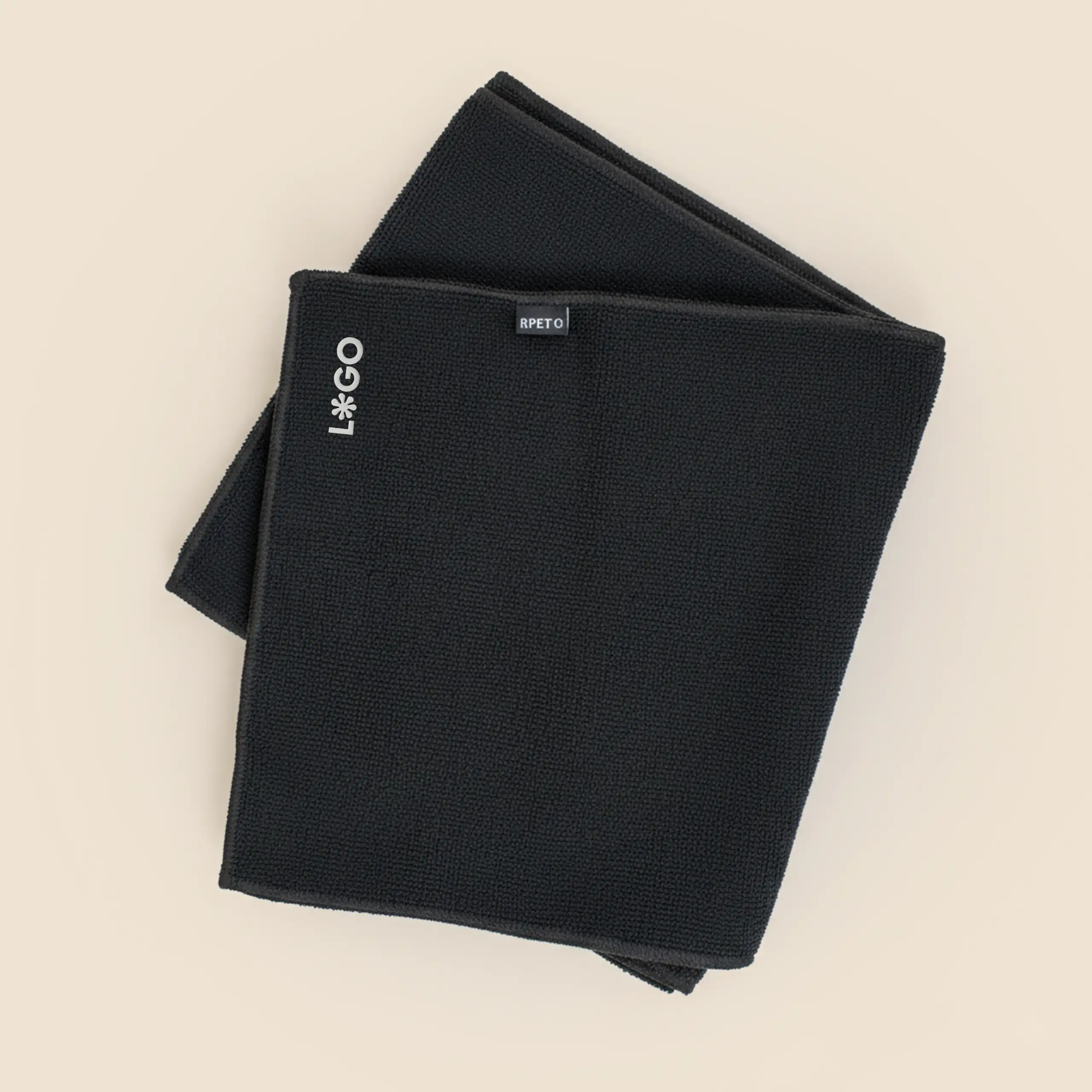 Toalla personalizada de gimnasio, de color negro y de material rpet. Con bordado en esquina de logo.