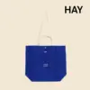 Bolsa tote de algodón orgánico de la marca HAY. Personalizable a todo color y a un color. De color azul y asas beige.