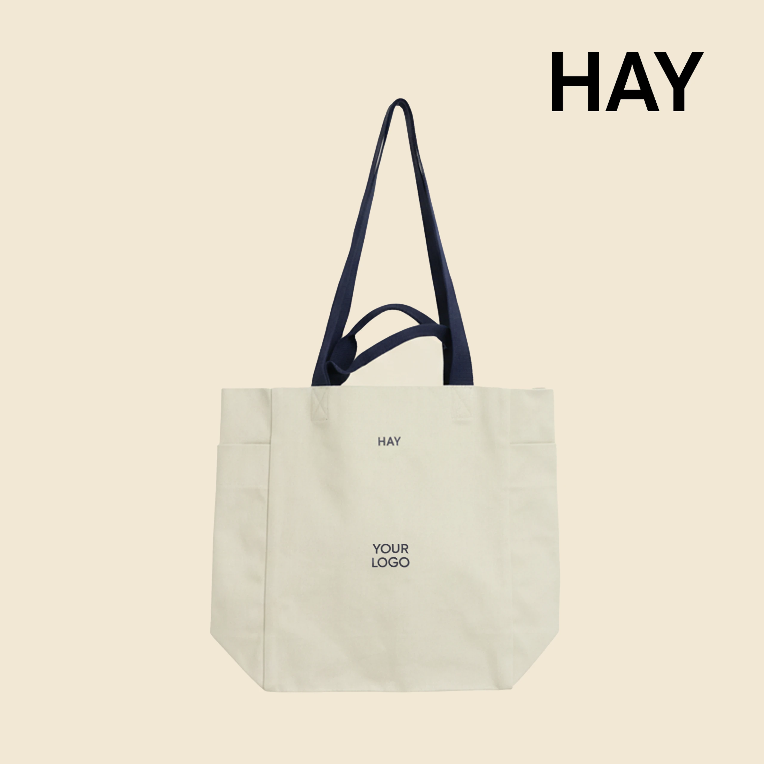 Bolsa tote de algodón orgánico de la marca HAY. Personalizable a todo color y a un color. De color beige y asas azul.