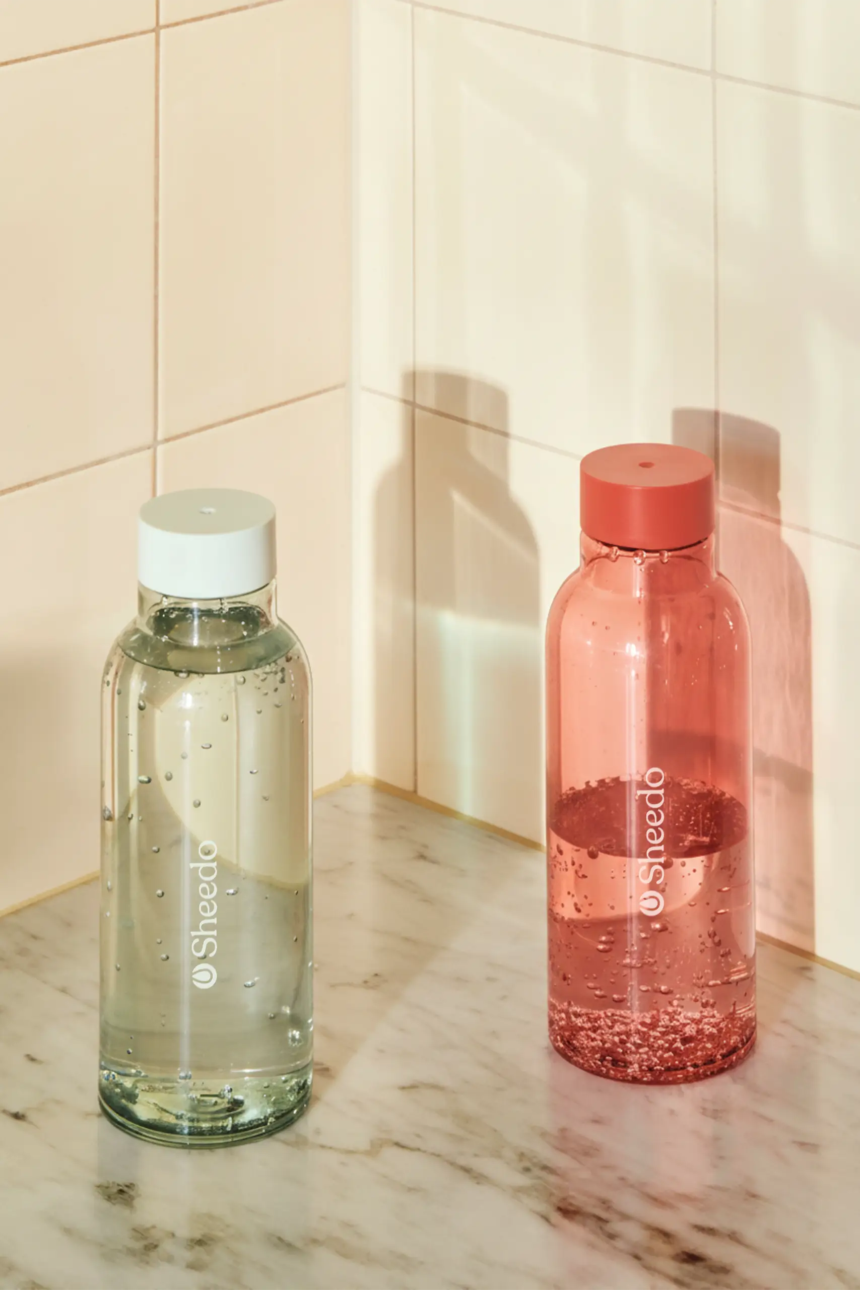 Botella minimalista de la marca HAY. De color rojo y azul transparente. Diseñada por el reconocido Naoto Fukasawa . Fabricada en PET reciclado.