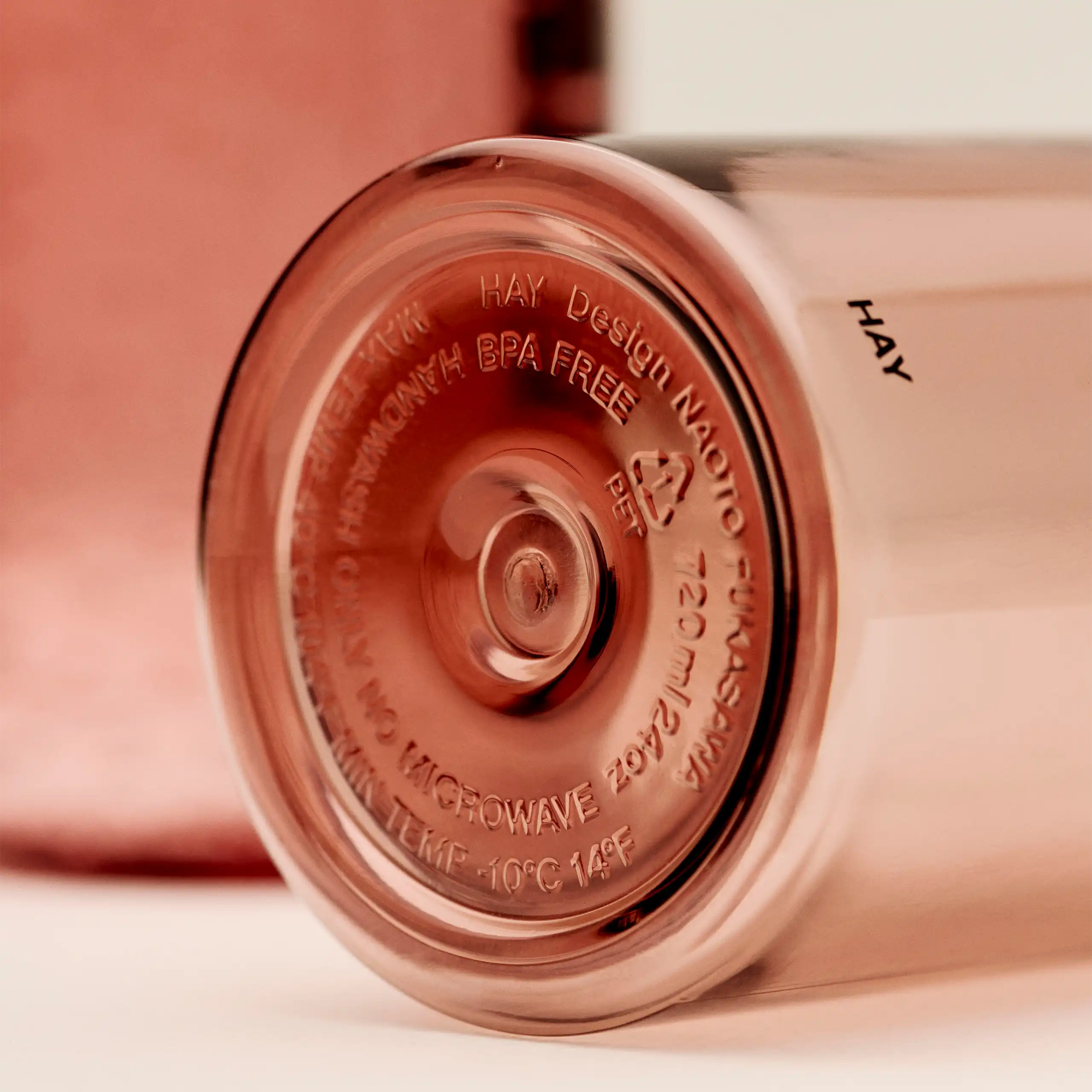 Botella minimalista de la marca HAY. De color rojo transparente. Diseñada por el reconocido Naoto Fukasawa . Fabricada en PET reciclado.