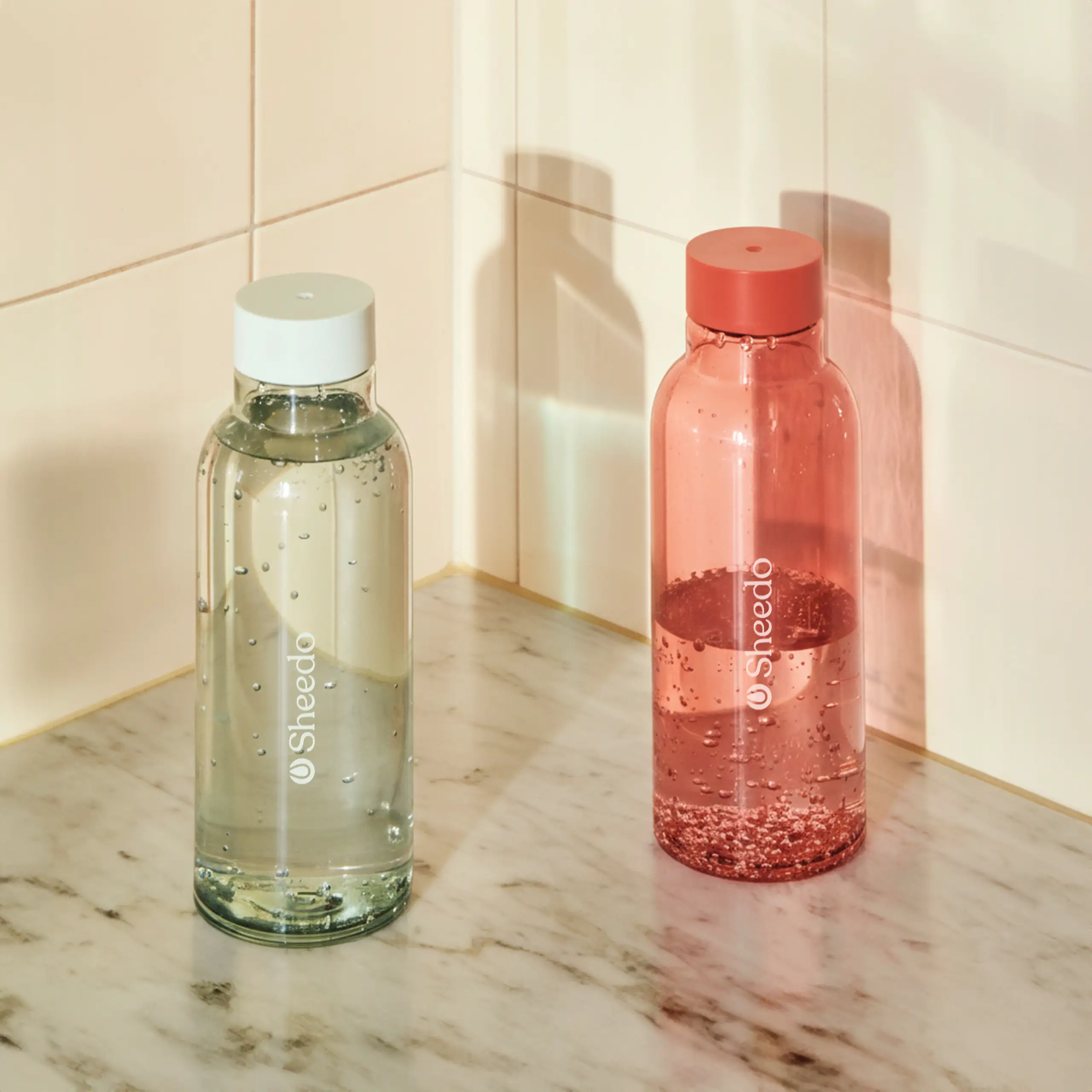 Botella minimalista de la marca HAY. De color rojo y azul transparente. Diseñada por el reconocido Naoto Fukasawa . Fabricada en PET reciclado.