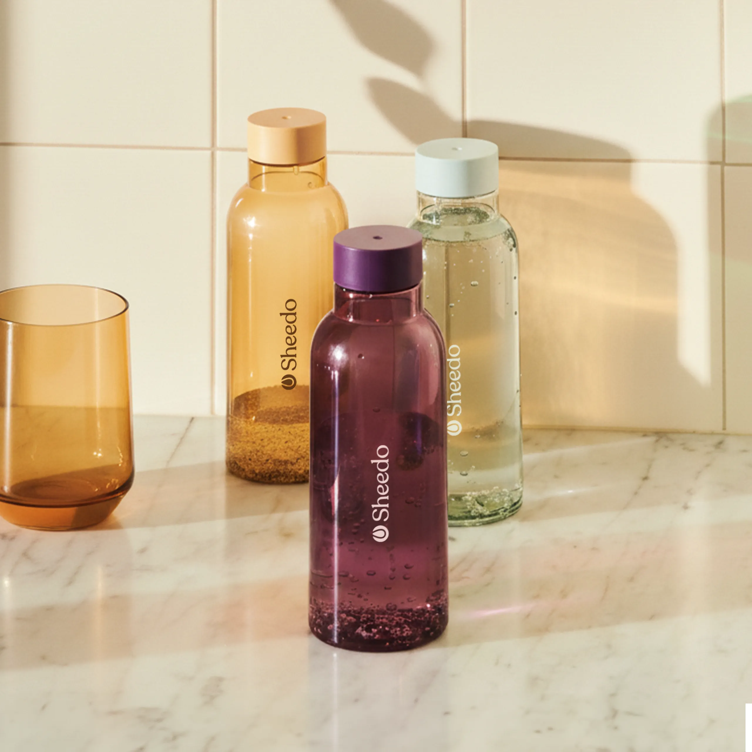 Botella minimalista de la marca HAY. De color púrpura, azul y amarillo transparente. Diseñada por el reconocido Naoto Fukasawa . Fabricada en PET reciclado.