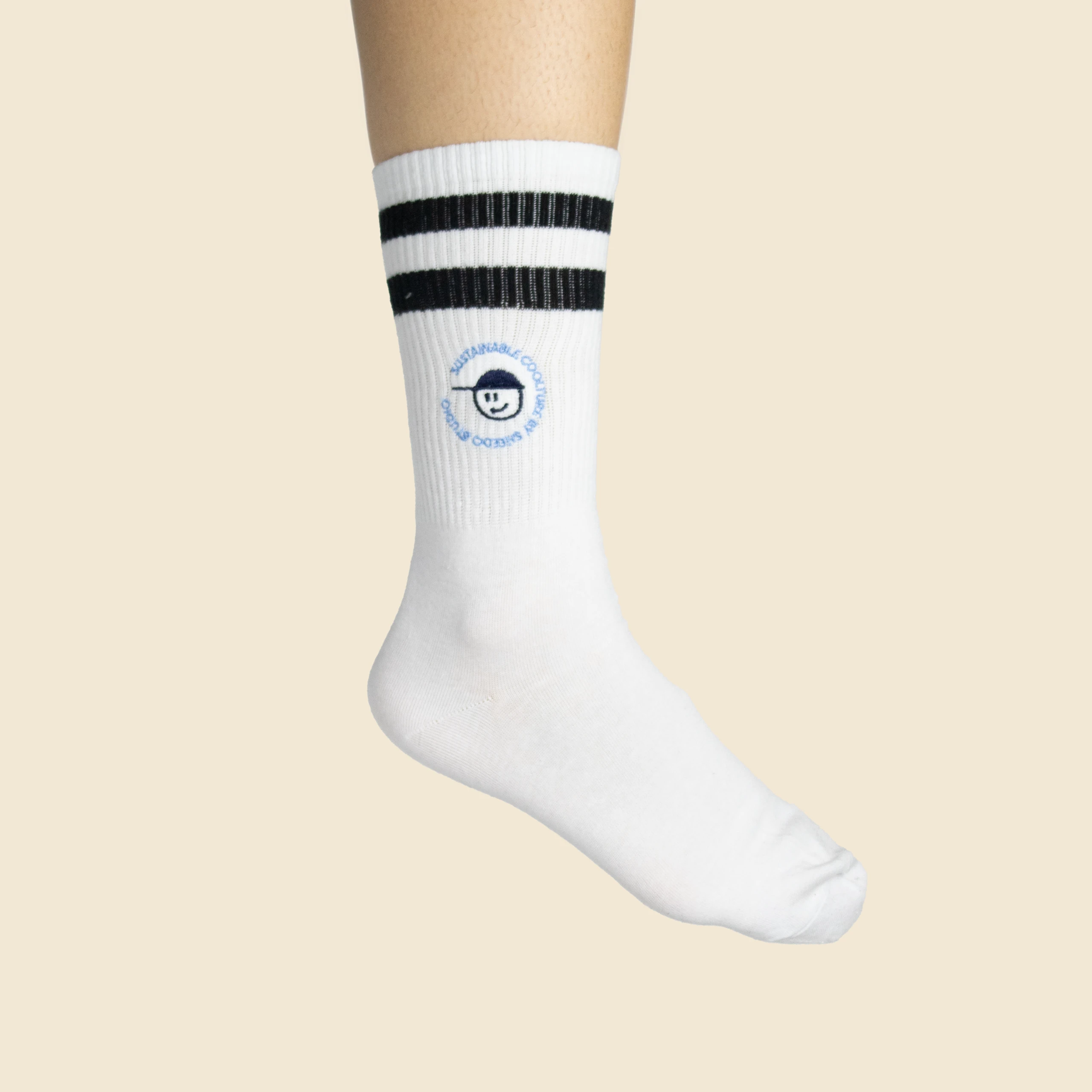 Calcetines bordados de algodón . Personalizables a todo color blancos con rayas negras. Puesto en un pie real.