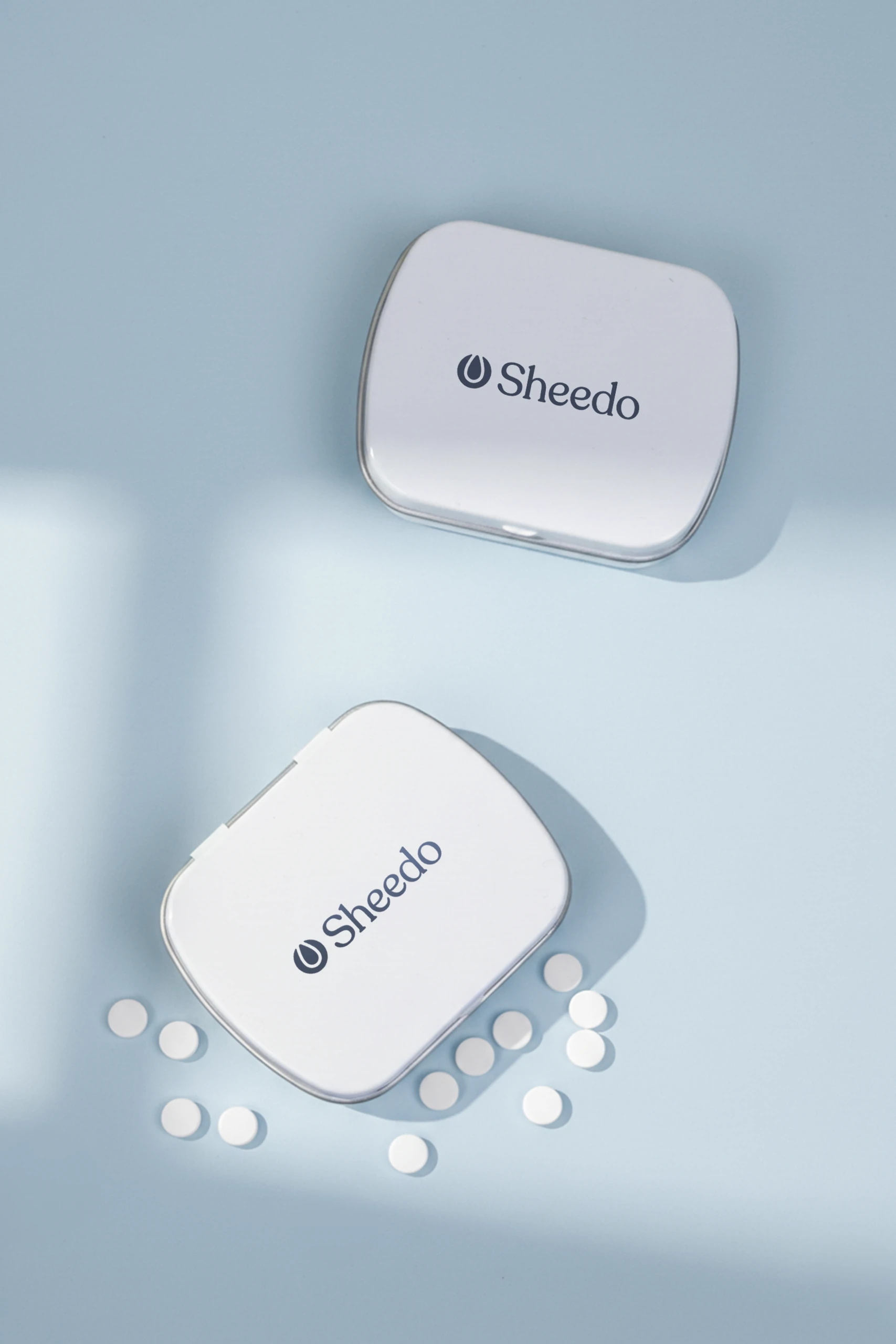 Dos cajas de caramelos blancas personalizadas con el logotipo de Sheedo