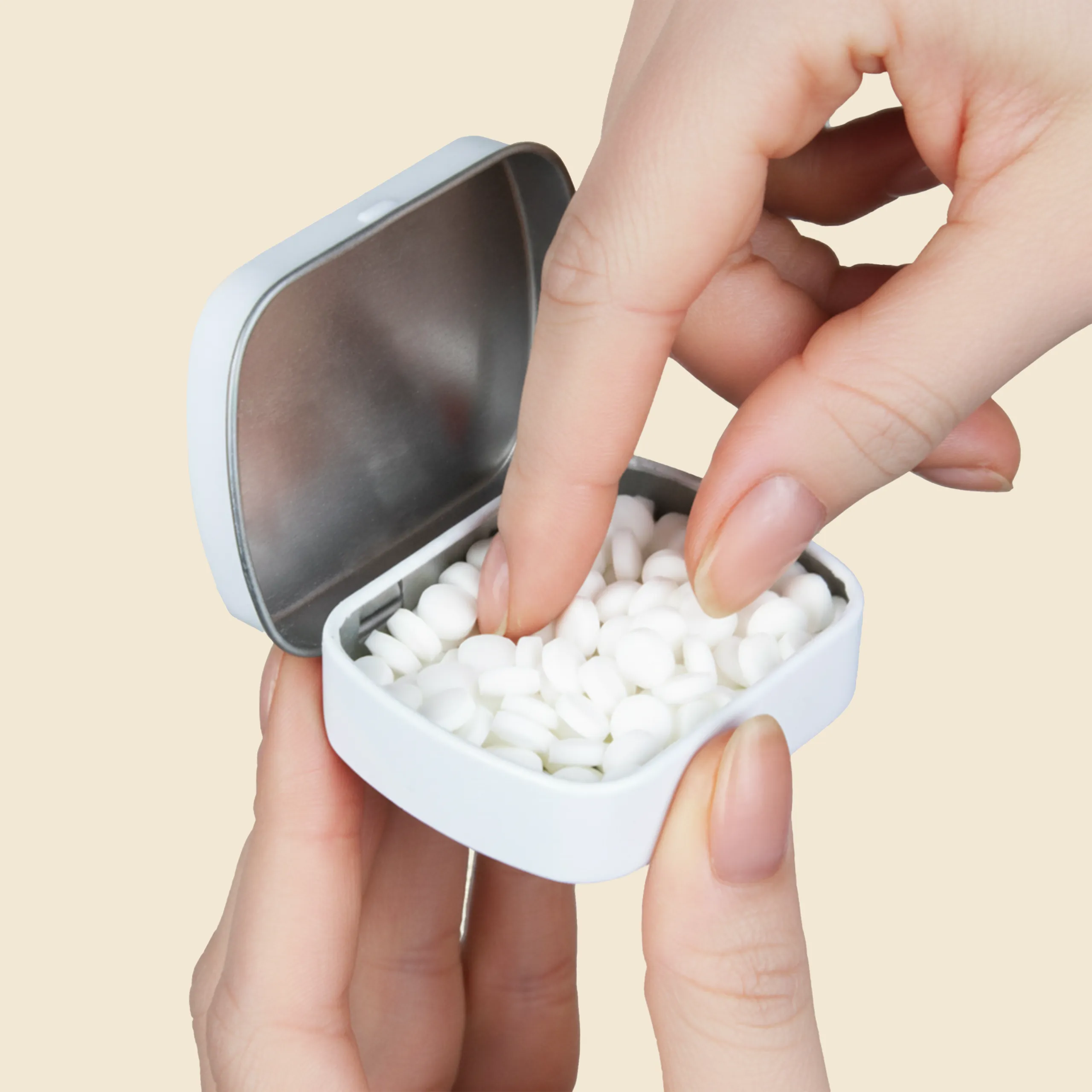 Mano abriendo una caja blanca de caramelos