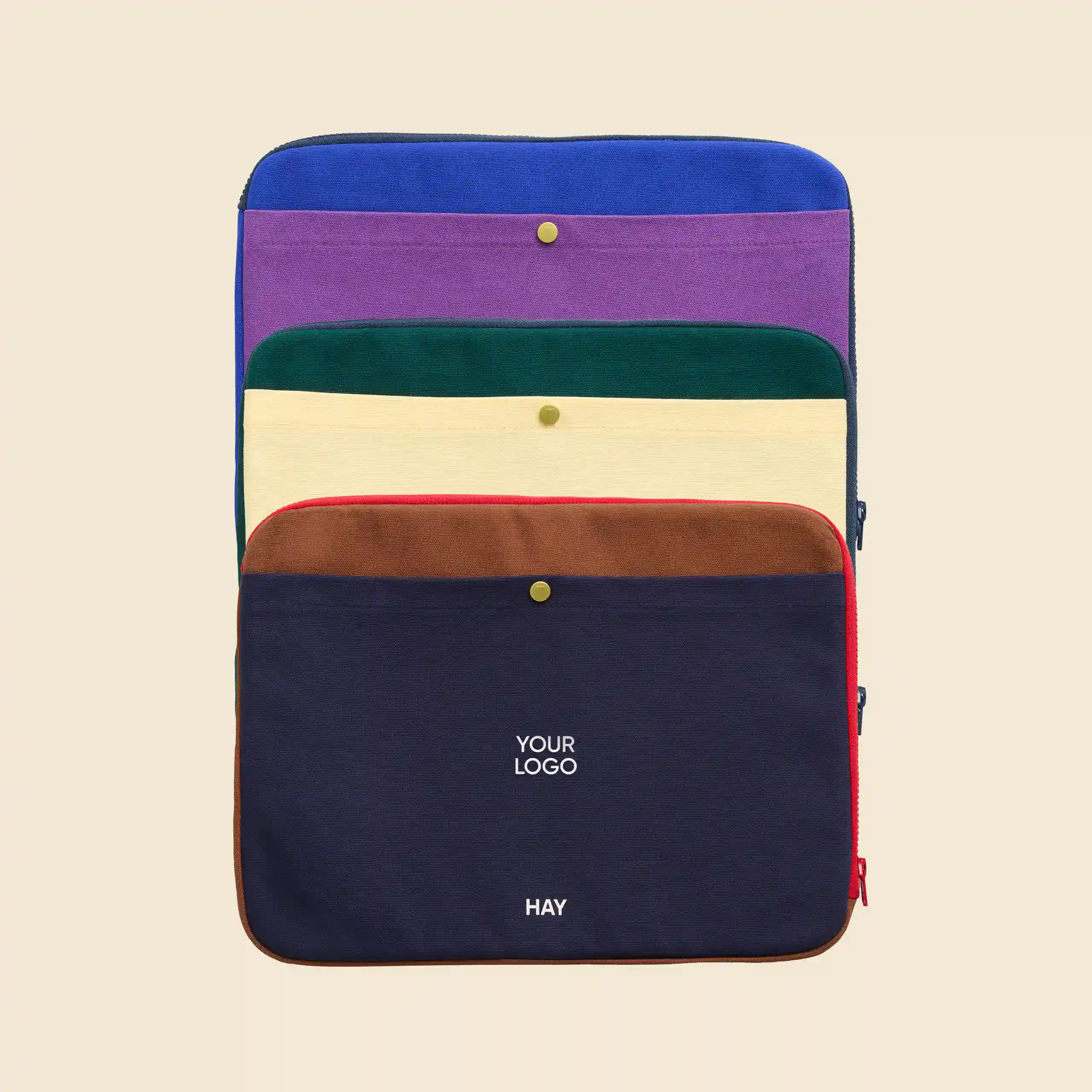 Funda de portátil de la marca HAY. Con botón dorado y cremallera. Combinado de colores.