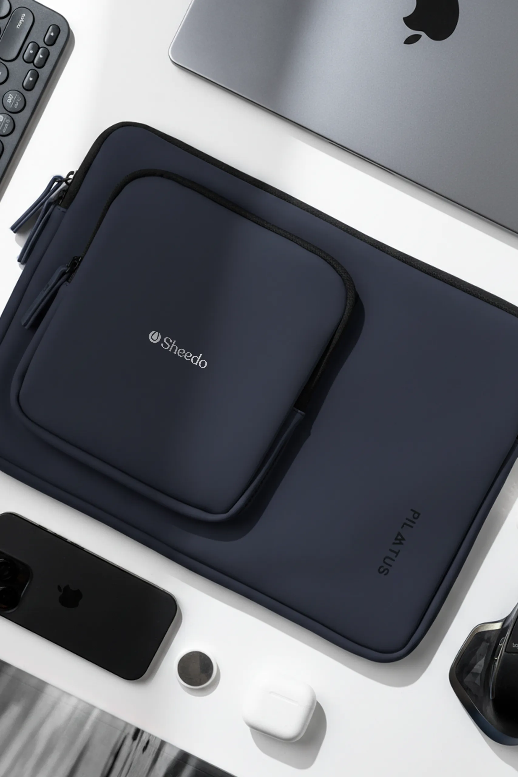 Funda de portátil - Pilatus Sleeve de 16'' pulgadas. De color azul y con personalización a una tinta. Colocada en una mesa de oficina.