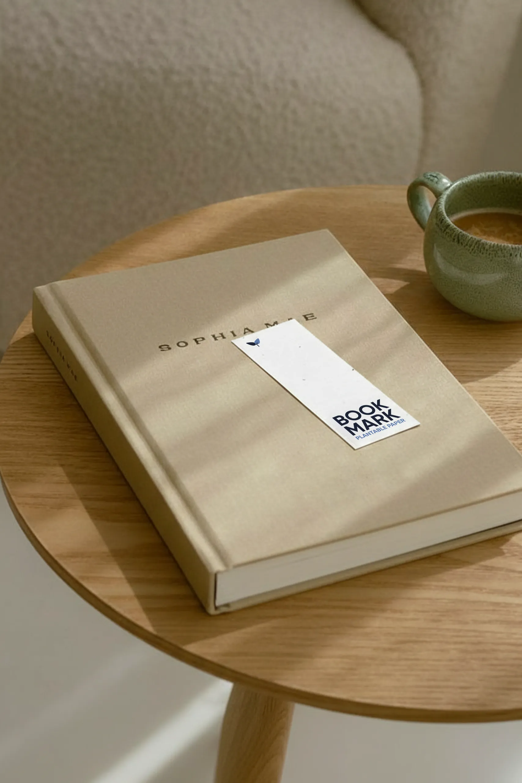 Marcapáginas de papel plantable colocado encima de un libro beige en una habitación acogedora.