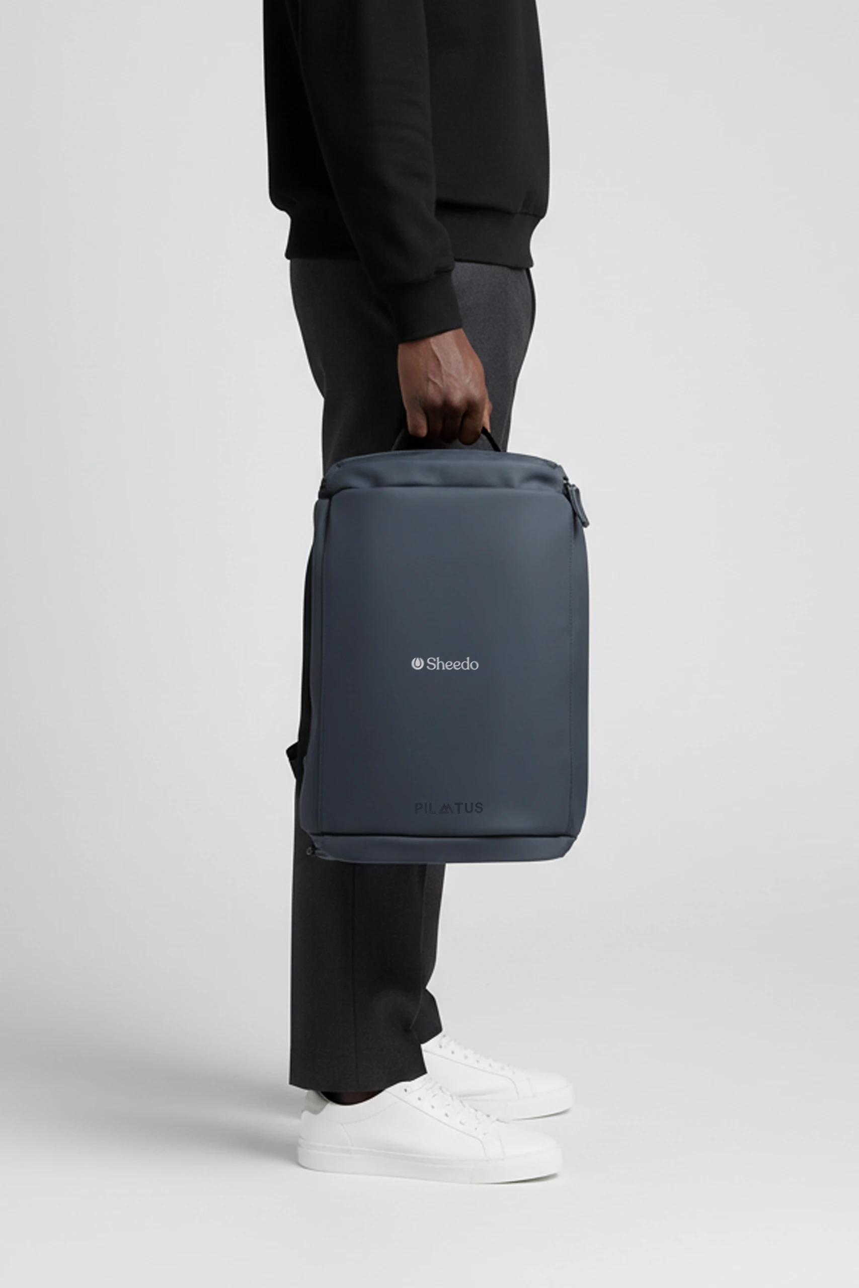 Mochila de diario de la marca Pilatus , de color azul marino y con personalización a 1 tinta. Sujeta por una persona.