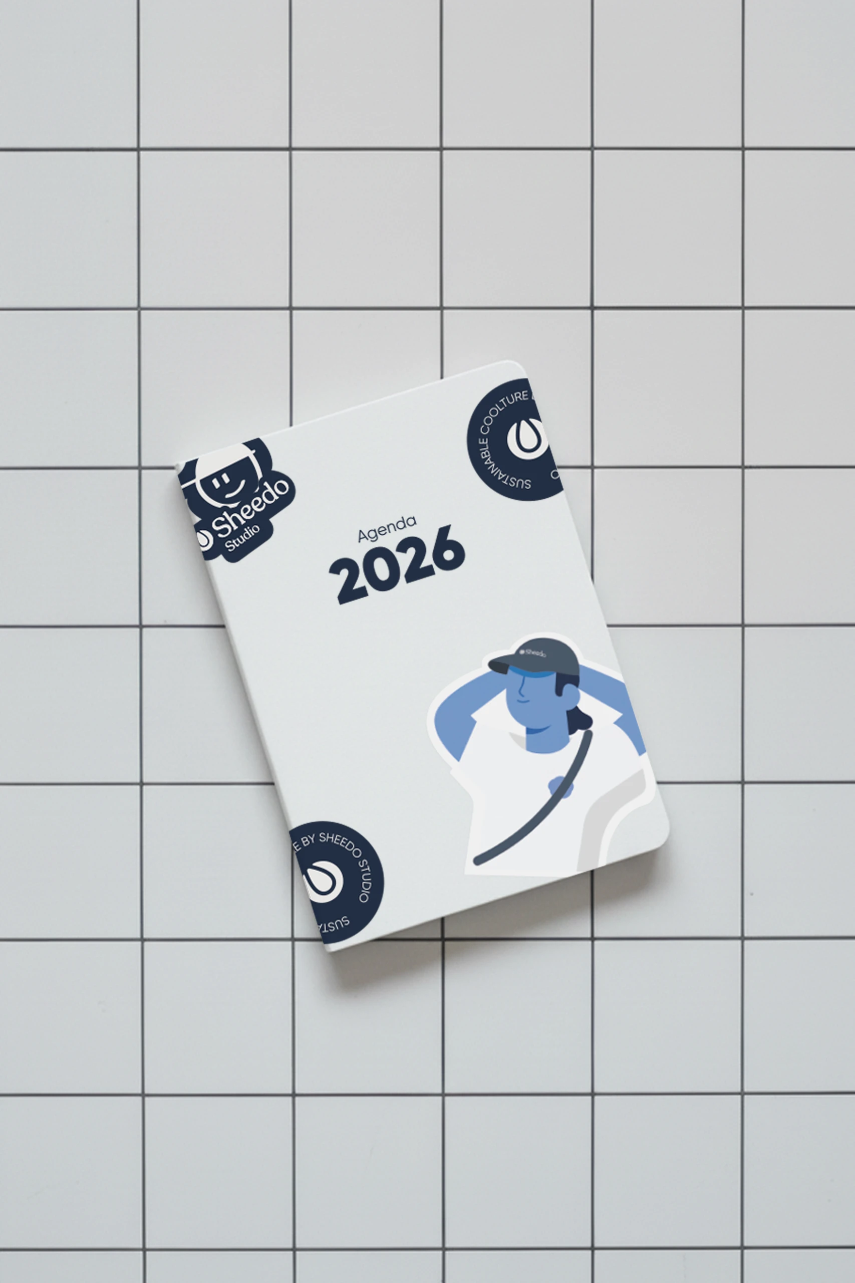 Pegatina de tamaño 5x5cm pegada en un cuaderno blanco.