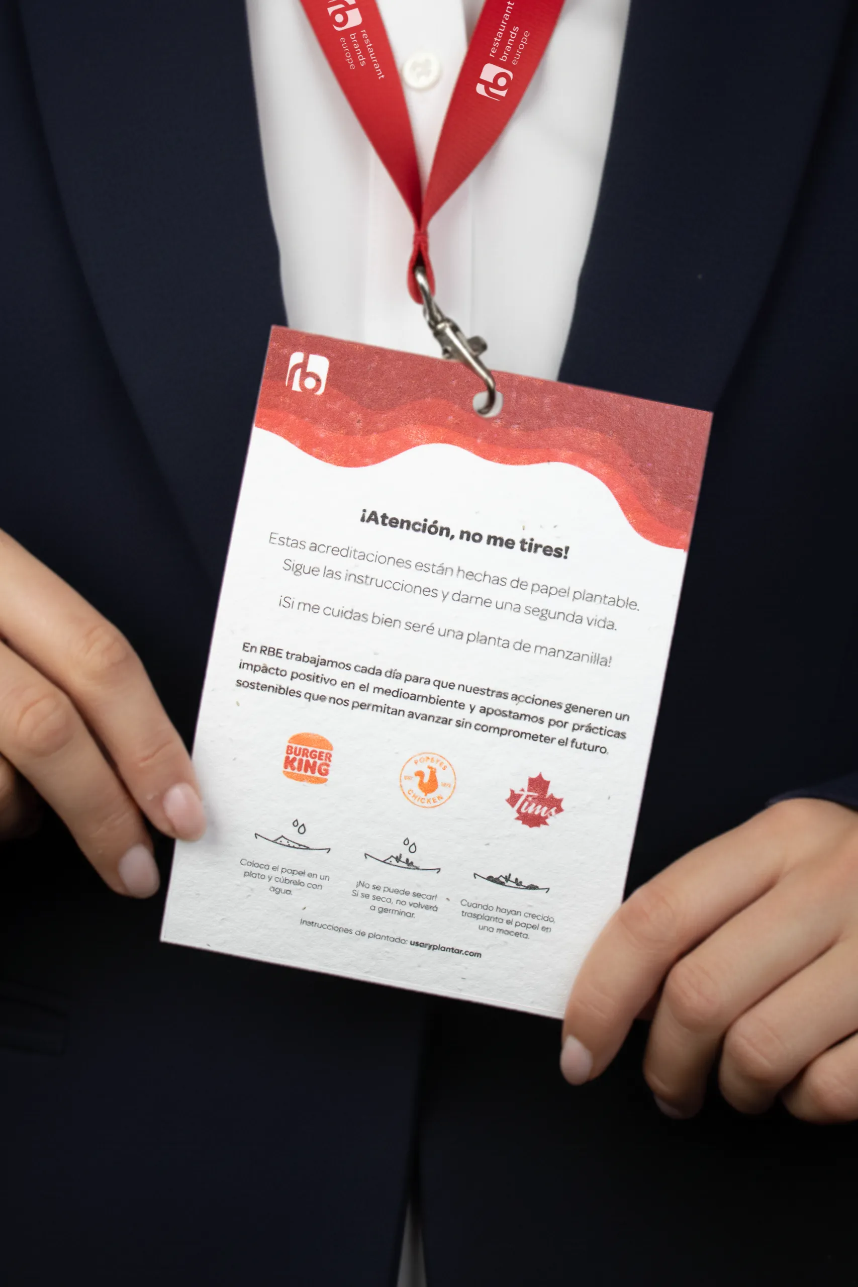 Acreditacion plantable con lanyard personalizada para la marca Restaurant Brands Europe, colgada del cuello de una chica