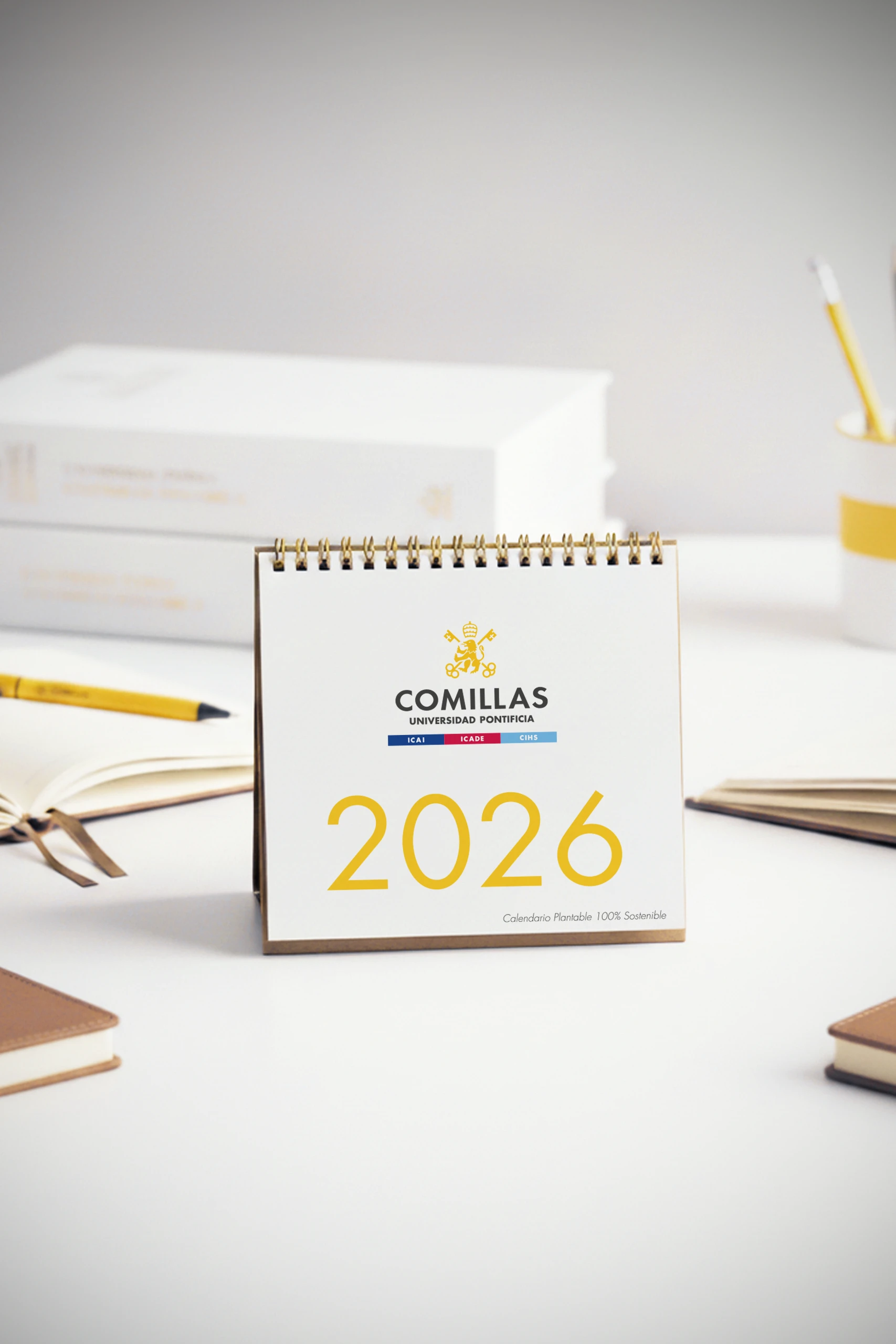 Calendario plantable 2026 personalizado para la Universidad Pontifica de Comillas, sobre una mesa blanca de escritorio