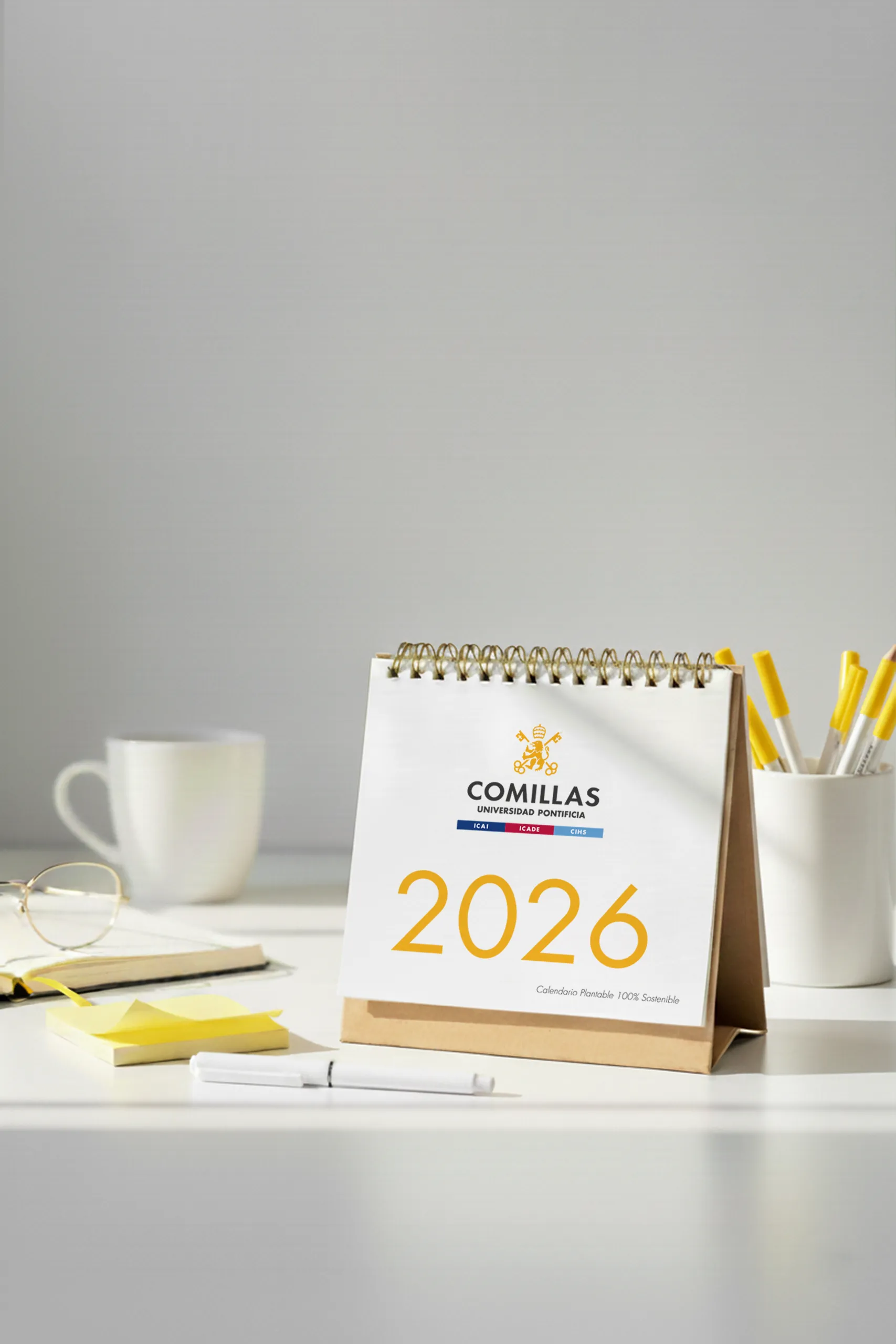 Calendario plantable 2026 personalizado para la Universidad Pontifica de Comillas, sobre una mesa blanca de escritorio