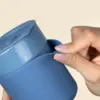 Vaso de cerámica ARCHI Mano manipulando un vaso de cerámica azul personalizado