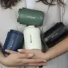 Chica sosteniendo en sus brazos 4 vasos térmicos personalizados con el logotipo de 'Sheedo'