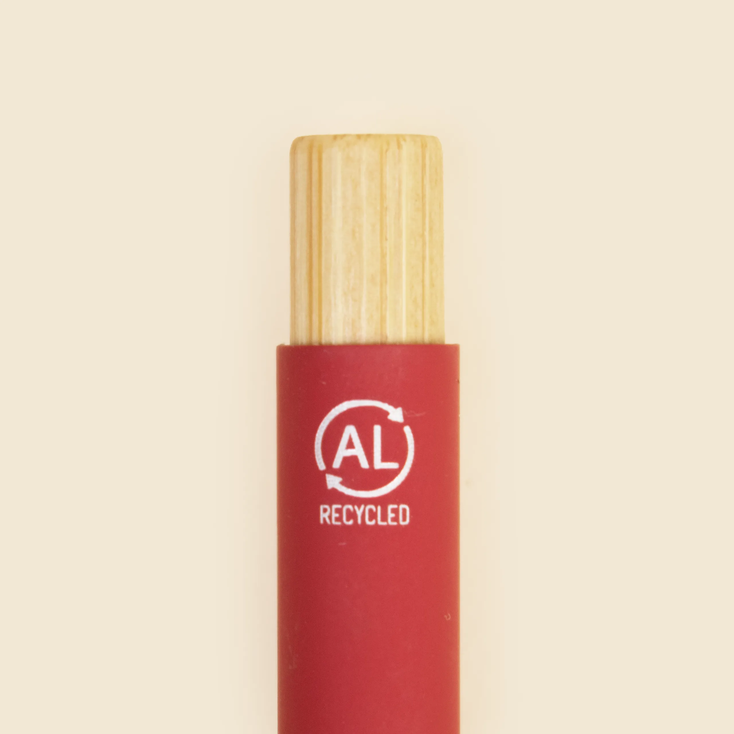 Detalle del pulsador de bambú de un bolígrafo rojo de aluminio reciclado