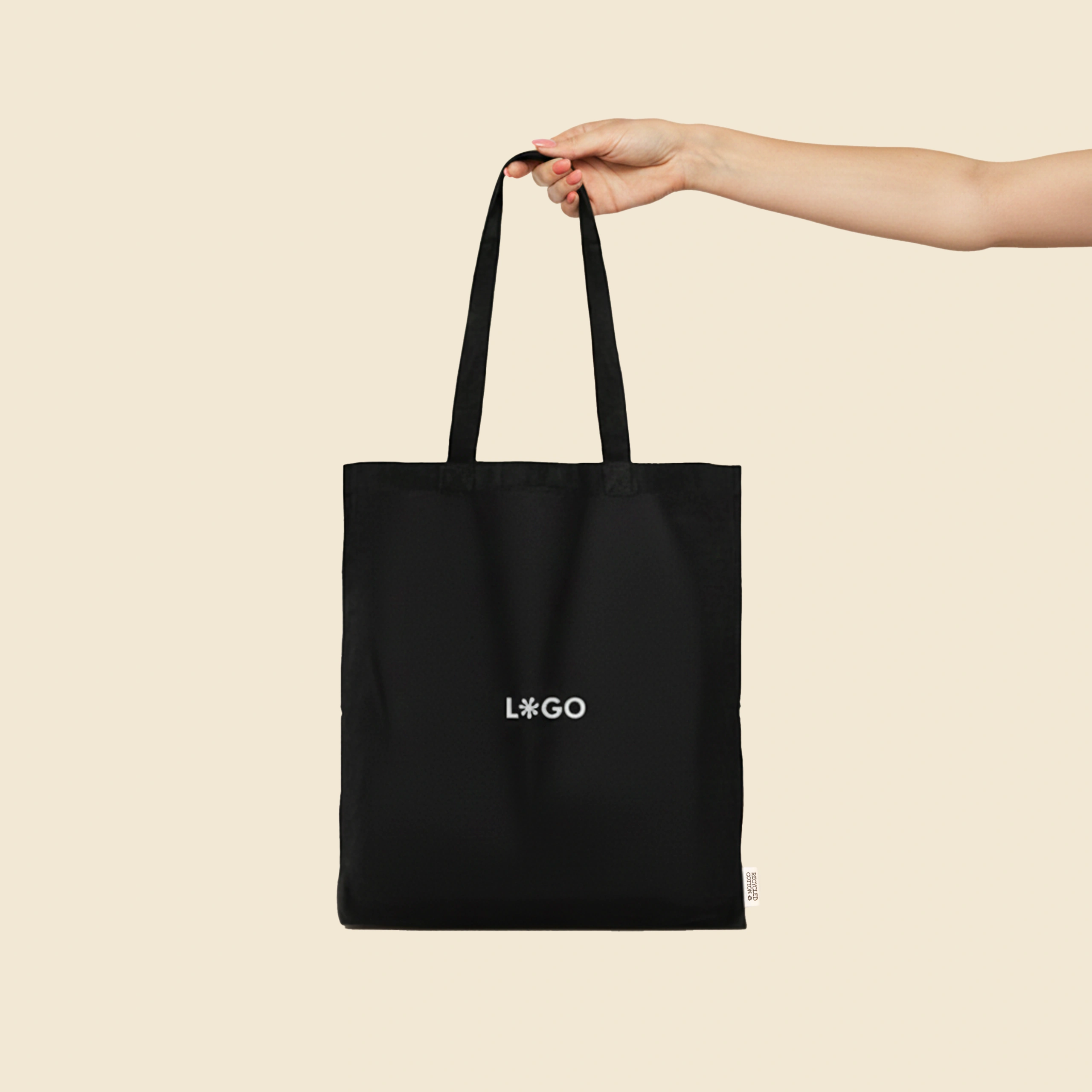 Bolsa de algodón reciclado de color negro con la palabra LOGO en blanco sujetado por una persona.