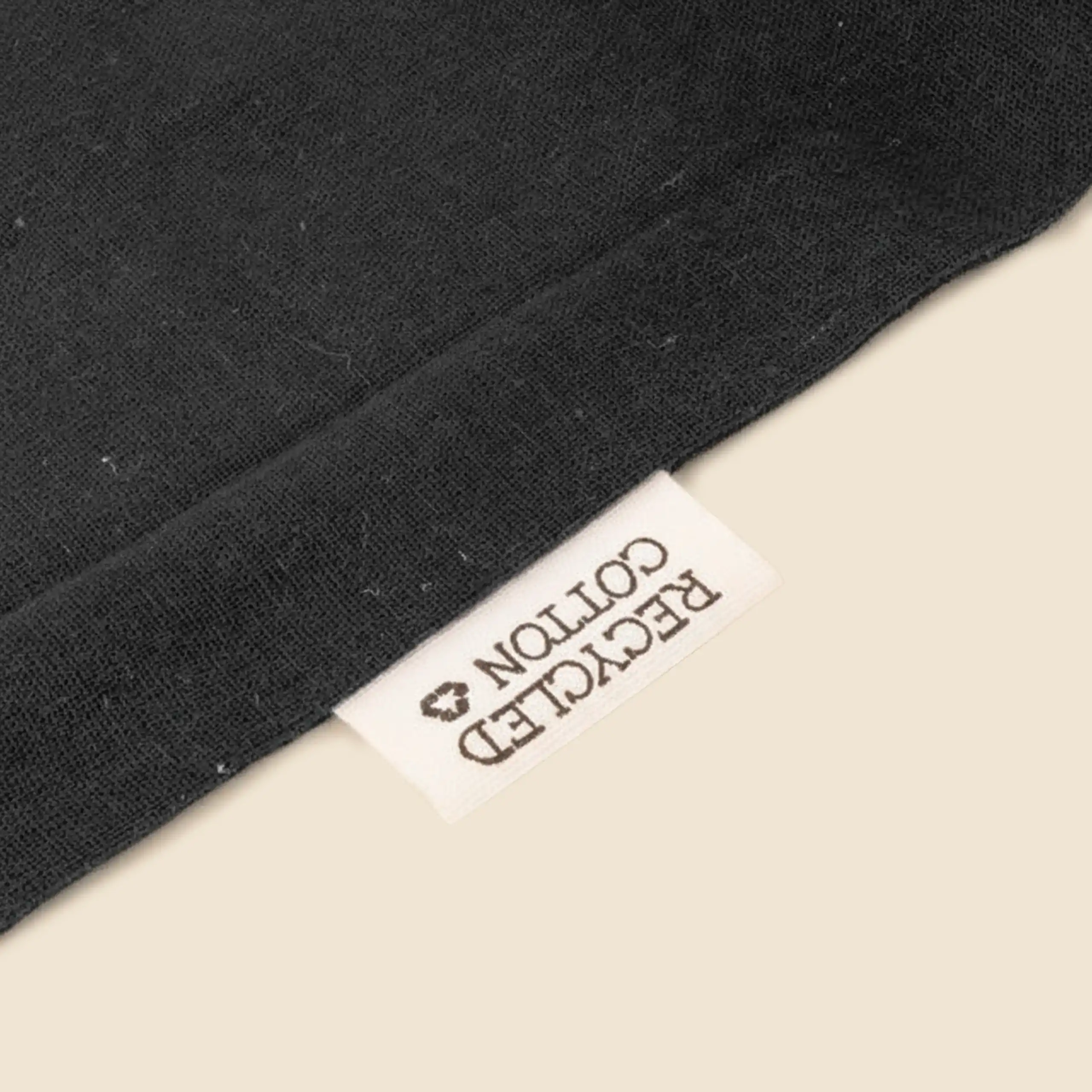 Etiqueta de Algodón reciclado en una bolsa de algodón reciclado de color negro.