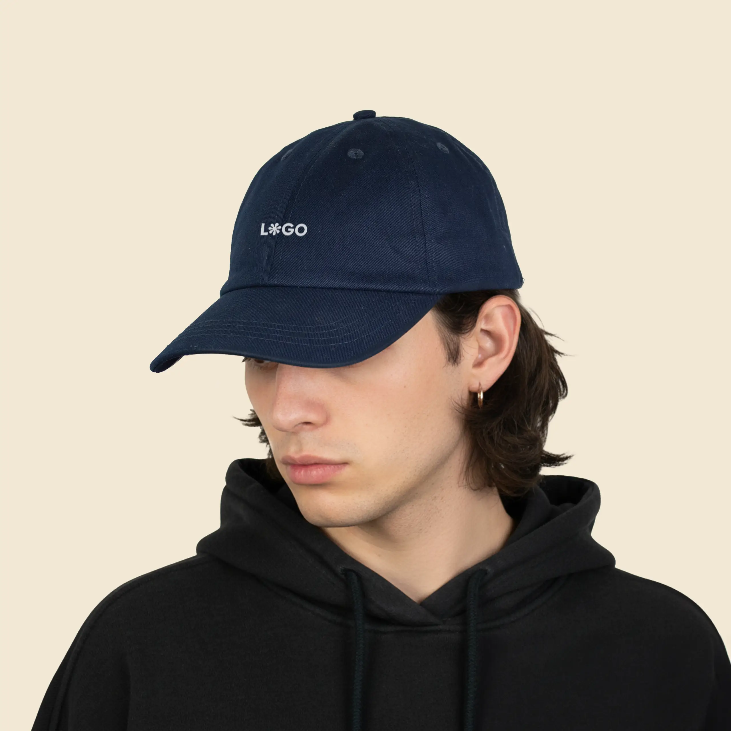 Gorra ecológica algodón orgánico GORKA chico con sudadera negra y una gorra ecológica de algodón de color azul marino, personalizada con la palabra 'logo' en blanco