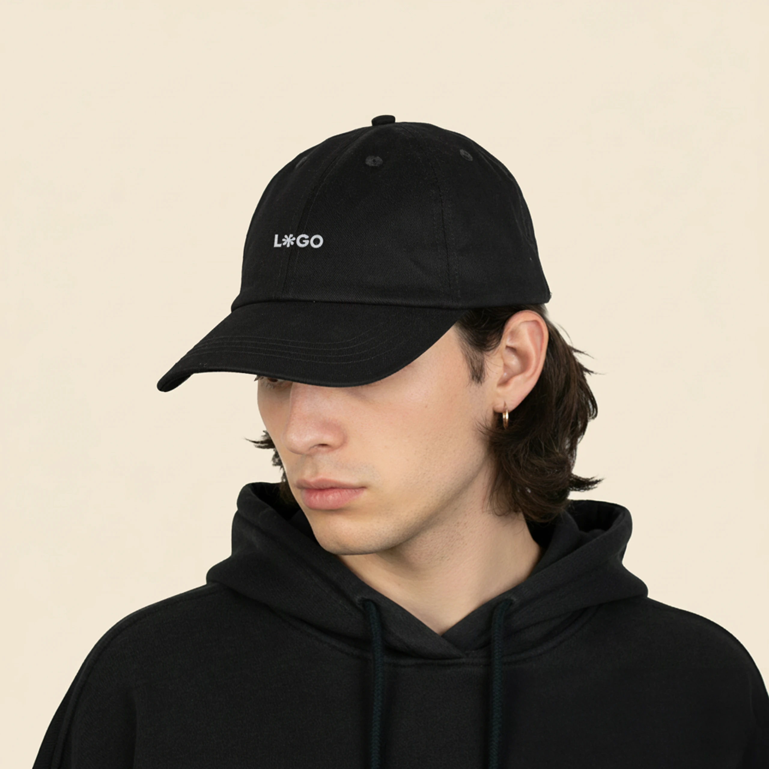 chico con sudadera negra y una gorra ecológica de algodón de color negro, personalizada con la palabra 'logo' en blanco