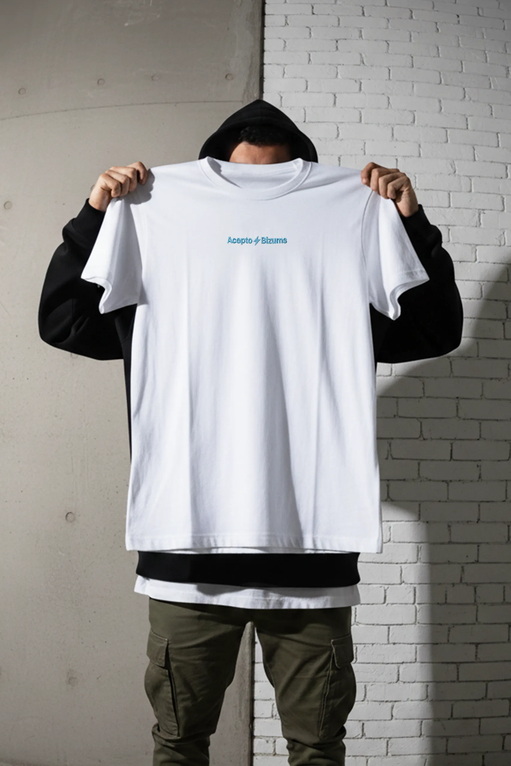 Chico mostrando una camiseta de algodón blanca personalizada con el logo de la marca BIZUM