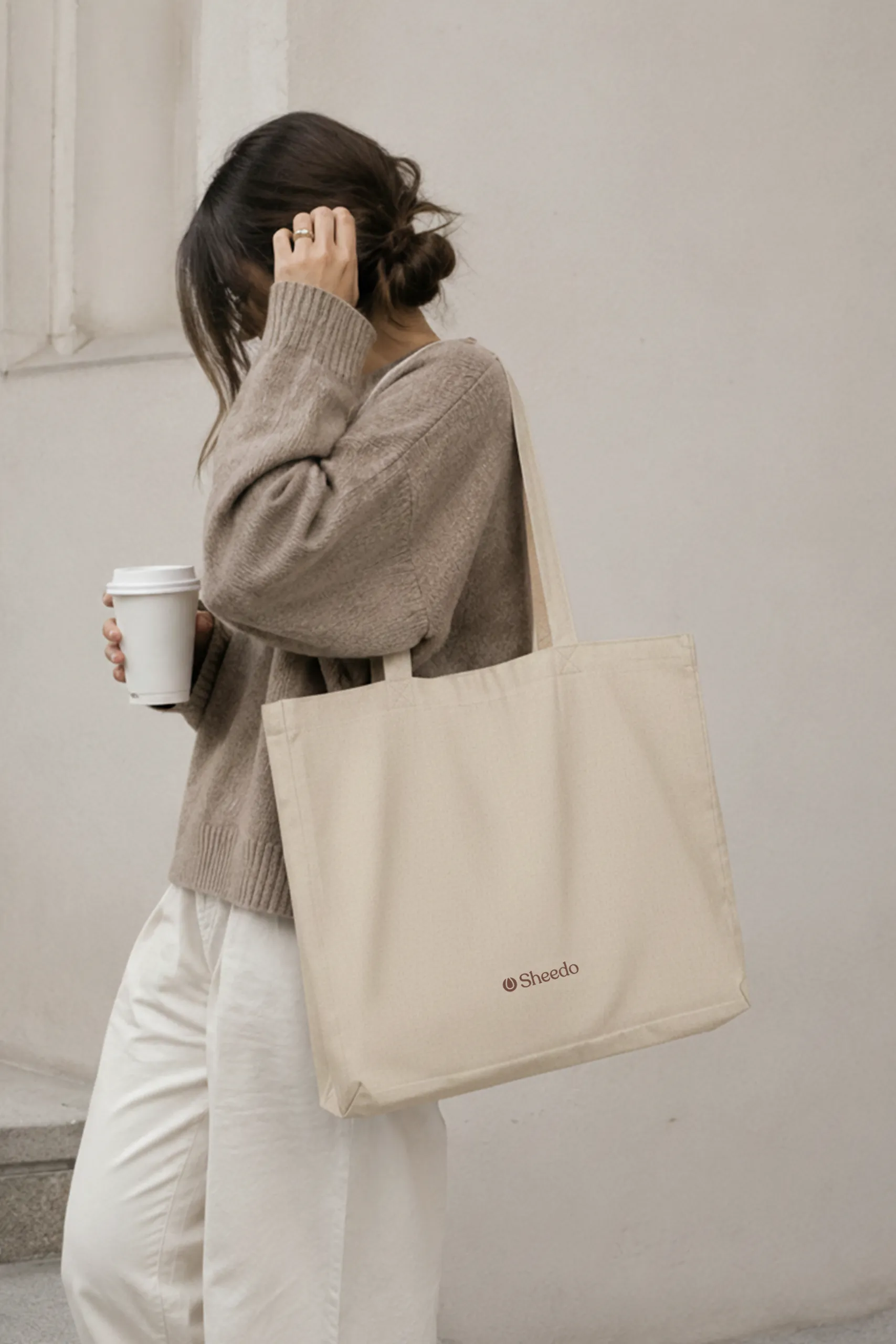 Chica en la calle sujetando una bolsa de algodón reciclado personalizada con logo