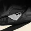 Detalle de un bolsillo interior con un movil dentro de una bolsa de viaje negra personalizada