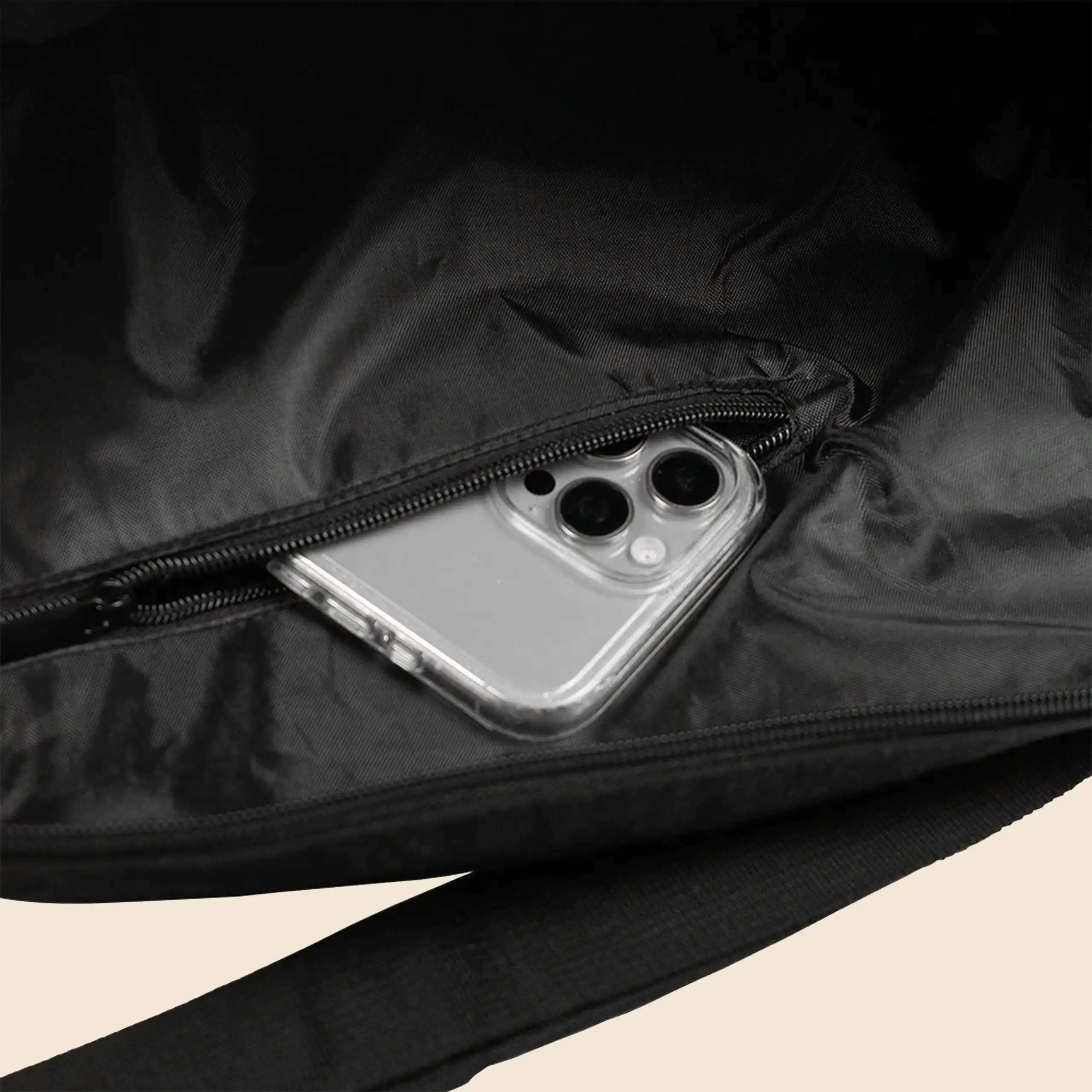 Detalle de un bolsillo interior con un movil dentro de una bolsa de viaje negra personalizada