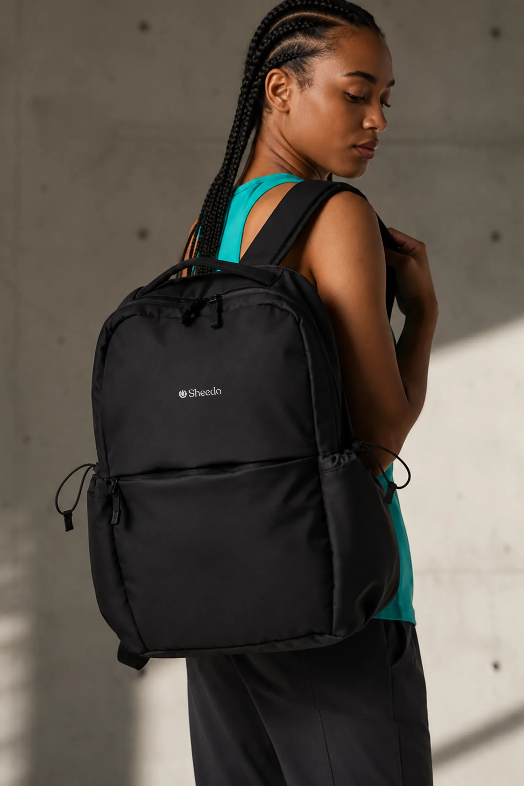 Chica con una mochila urbana colgada sobre su hombro personalizada negra en un exterior