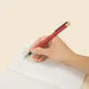 Roller de aluminio reciclado rojo con mano escribiendo , personalizado con la palabra LOGO en blanco