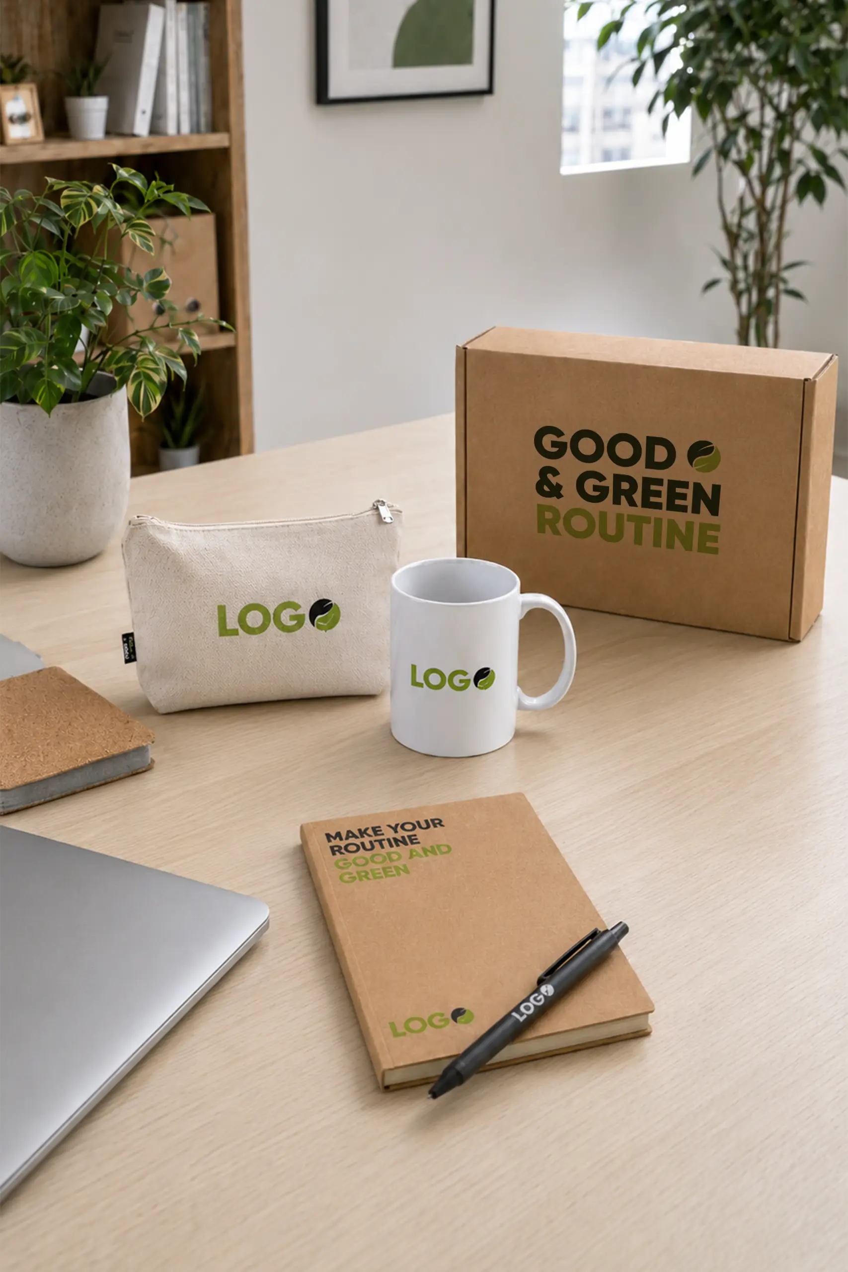 Welcome pack "Good & Green Routine" con caja de cartón kraft, neceser de tela color crudo con espacio para "LOGO", taza blanca y libreta kraft con el mensaje "Make your routine good and green", junto con un bolígrafo negro, todo presentado en un escritorio con plantas y un ordenador portátil.