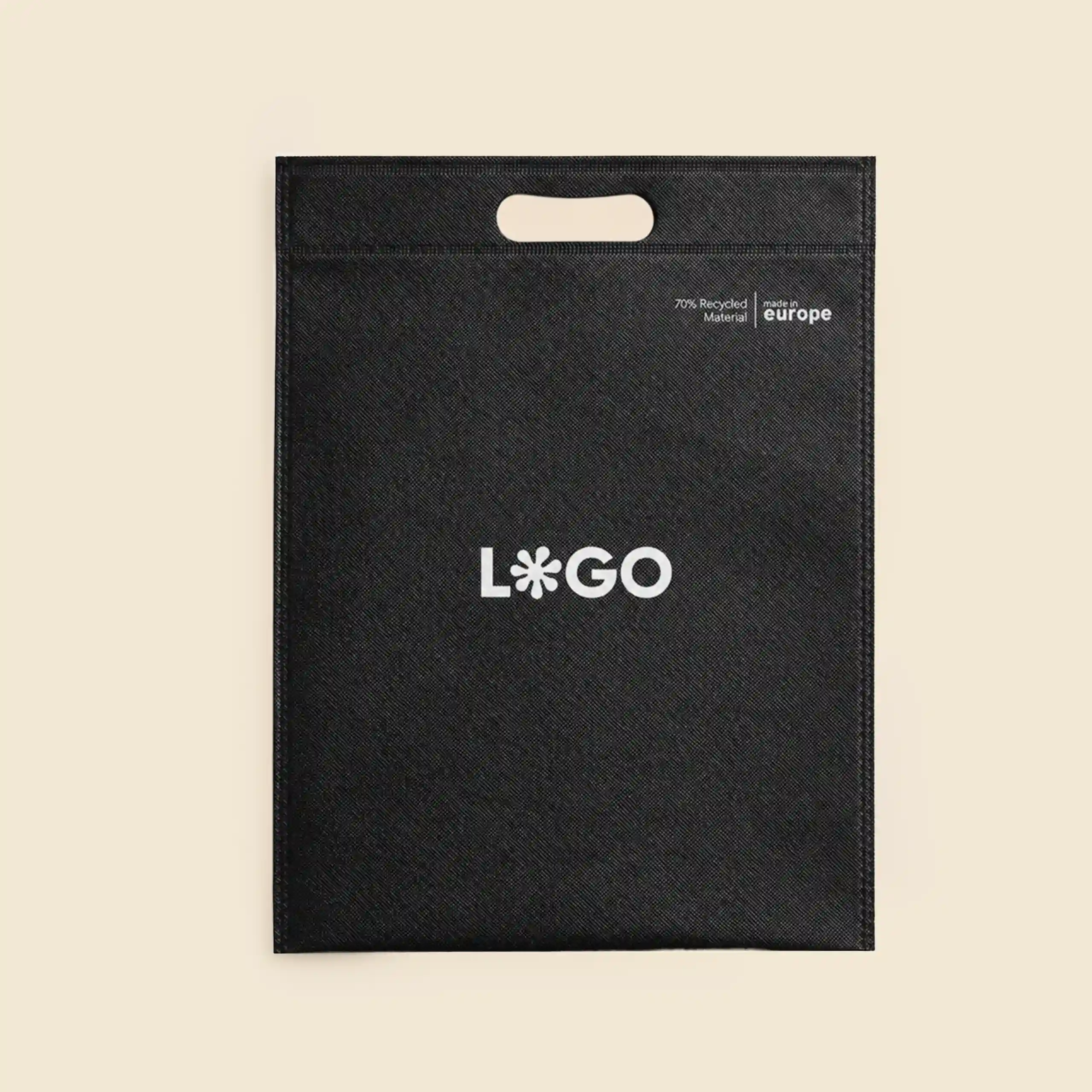 Bolsa negra en non woven reciclado con asa troquelada, logo personalizado y sello "70% Recycled Material, made in Europe", fondo beige.