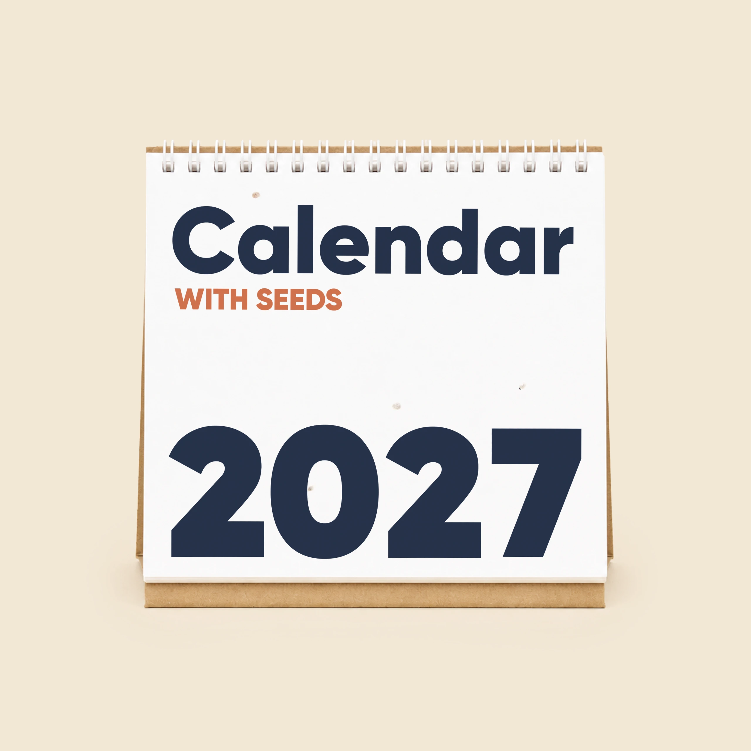 Plantable desk calendar TRIGA Triangular plantable desktop calendar with a kraft cardboard base, placed on a minimalist beige desk, showing the cover with the "Sheedo 2027 With Seeds" logo alongside a lamp, a plant and a stone vase.