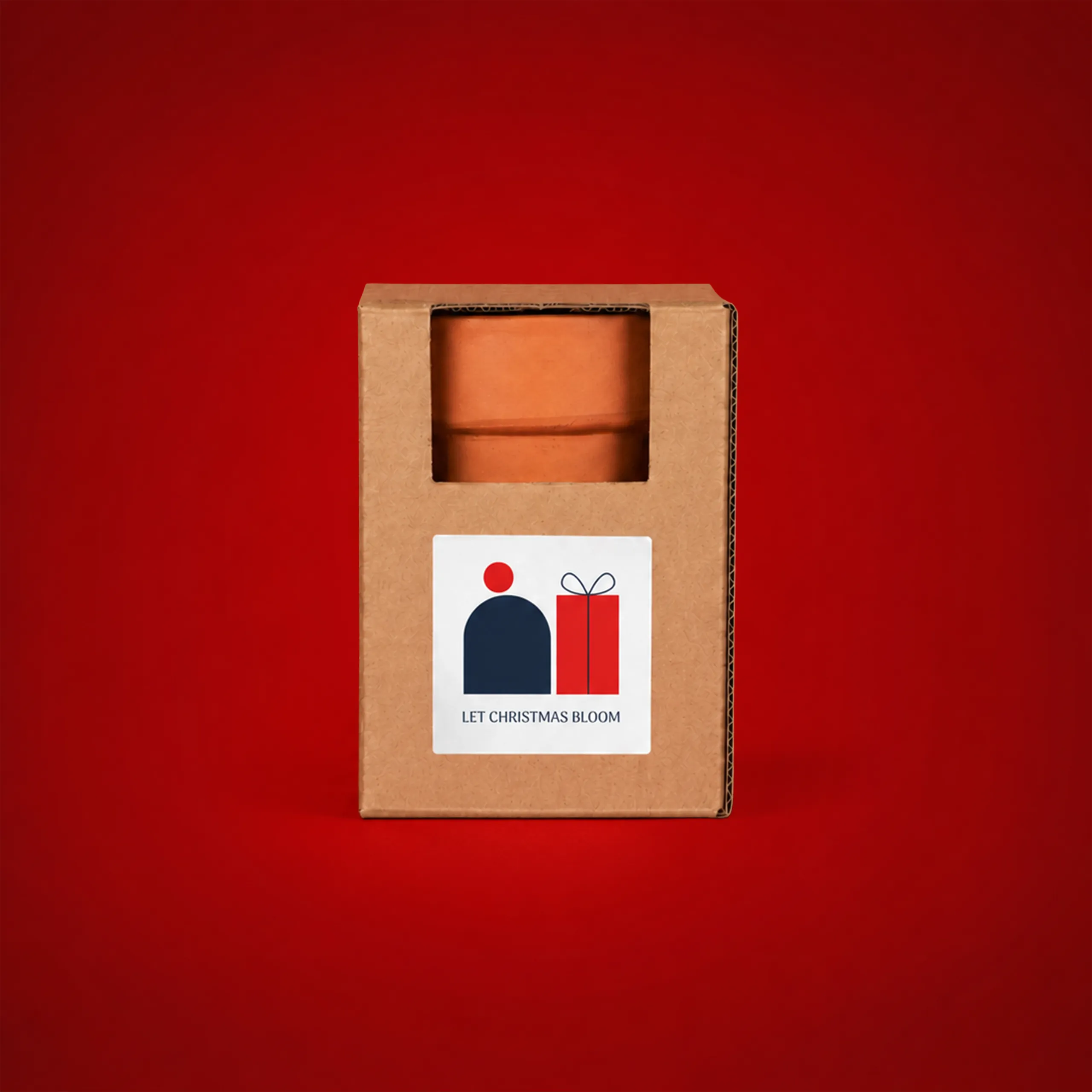 Kit plantable de barro_COCOT Kit plantable de barro en su caja de cartón kraft con ventana troquelada mostrando la maceta de terracota, y una etiqueta con el texto "Let Christmas Bloom", sobre fondo rojo.