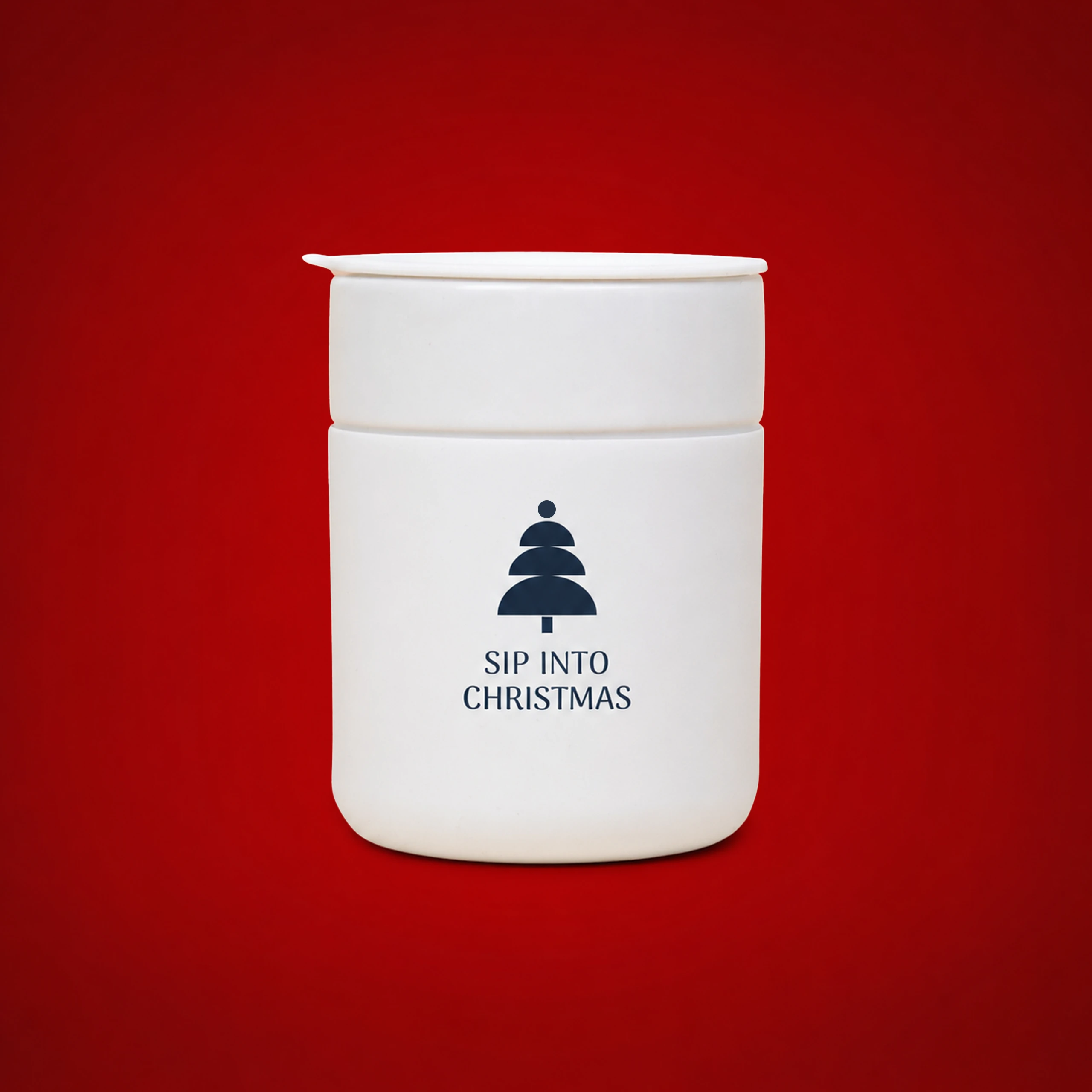 Vaso de cerámica personalizado_ARCHI Vaso de cerámica personalizado en blanco con el texto "Sip into Christmas" y un árbol de Navidad estilizado en azul marino, sobre fondo rojo.