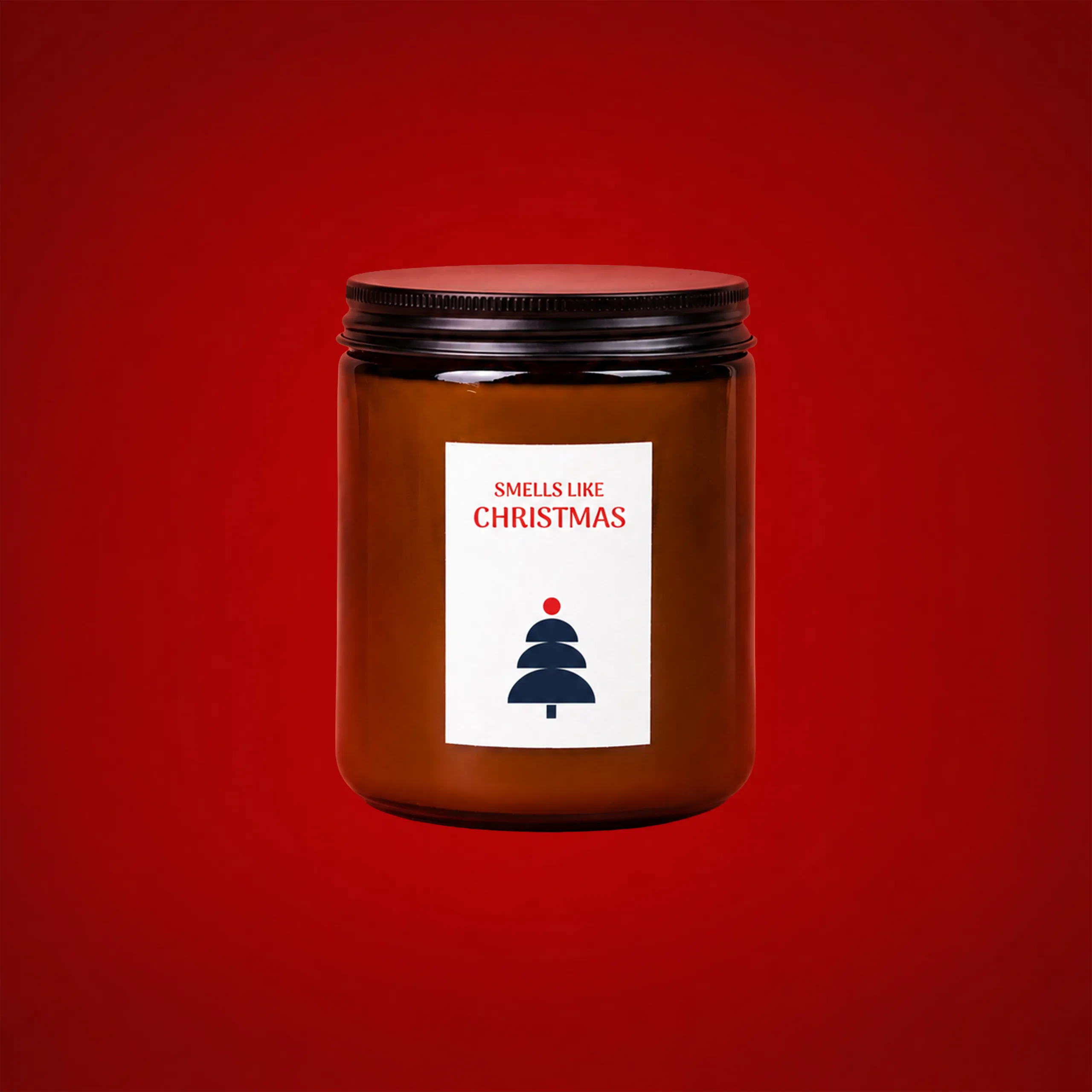 Vela ecológica de soja personalizable en tarro ámbar con tapa negra, con etiqueta blanca que muestra el texto "Smells like Christmas" y un árbol de Navidad ilustrado, sobre fondo rojo.