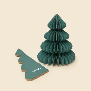 Árbol de Navidad de papel plegable en color verde oscuro junto a su pieza plana en forma de árbol con el espacio para el texto "LOGO" en blanco, mostrando el proceso de montaje.