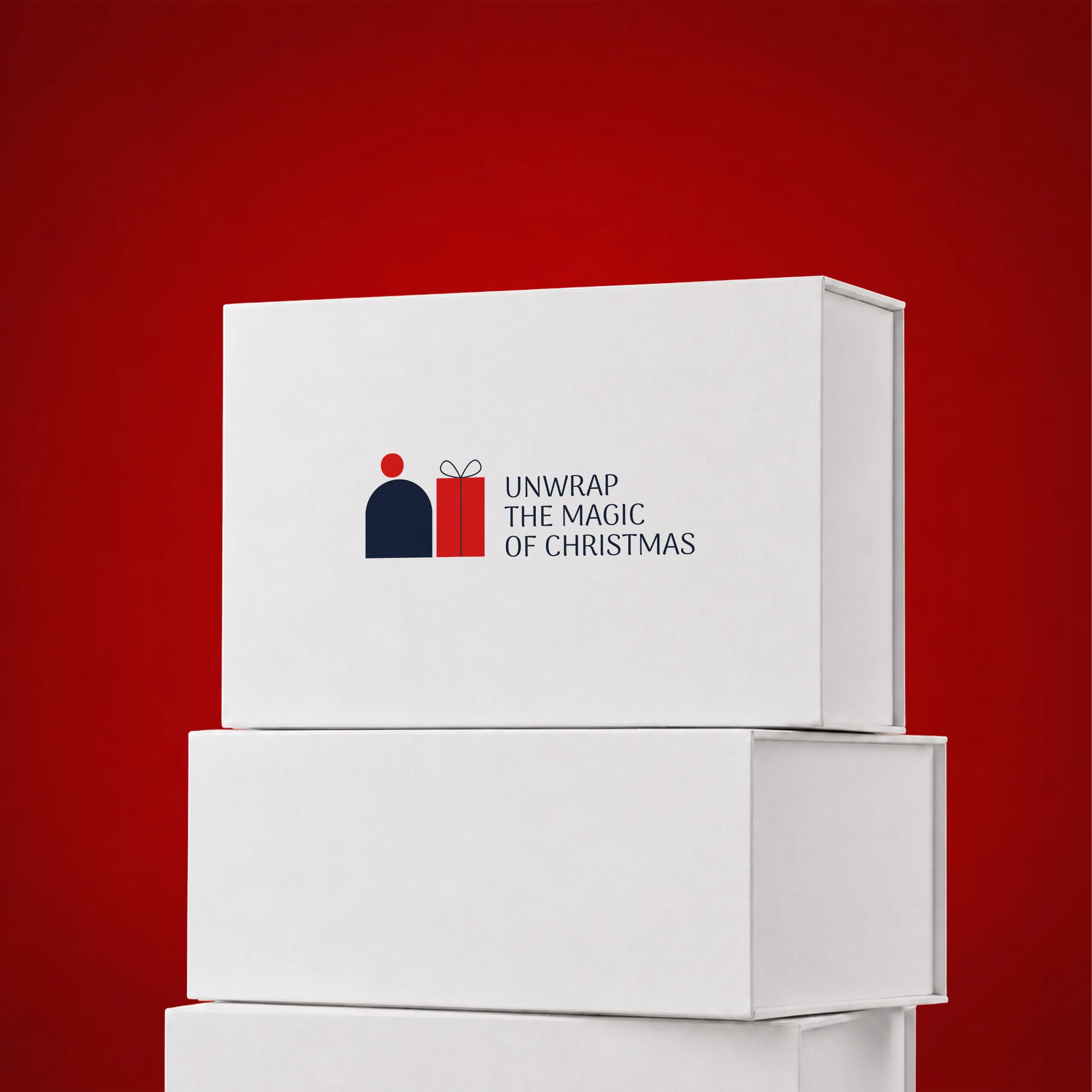 Stack of white magnetic-closure gift boxes on a festive red background, with a gift icon and the "Unwrap the magic of Christmas" message printed on the lid.