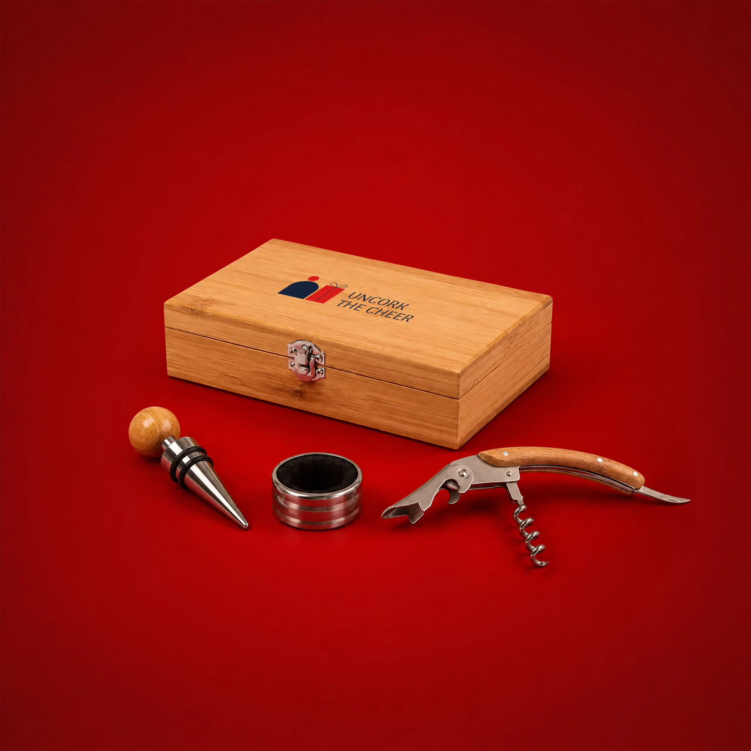 Personalised wine set with a bamboo box and the "Uncork the cheer" message, accompanied by a stopper, drip ring and corkscrew, on a festive red background.