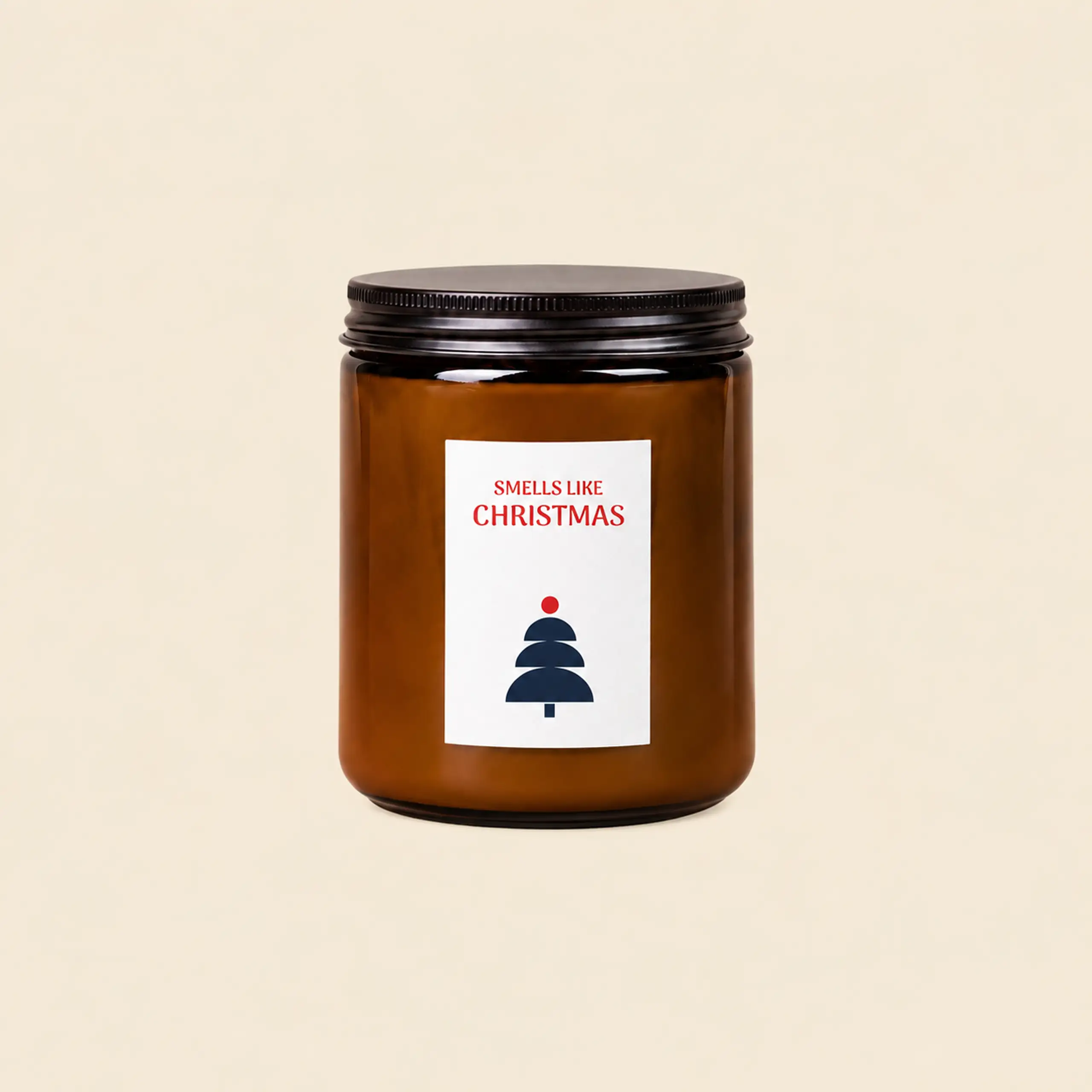 Vela en tarro de cristal ámbar con tapa negra, etiqueta con árbol azul marino y «Smells like Christmas» en rojo.